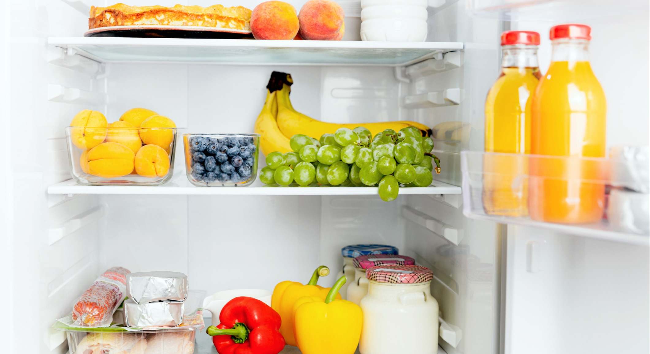 Nevera llena de frutas frescas, verduras y zumos