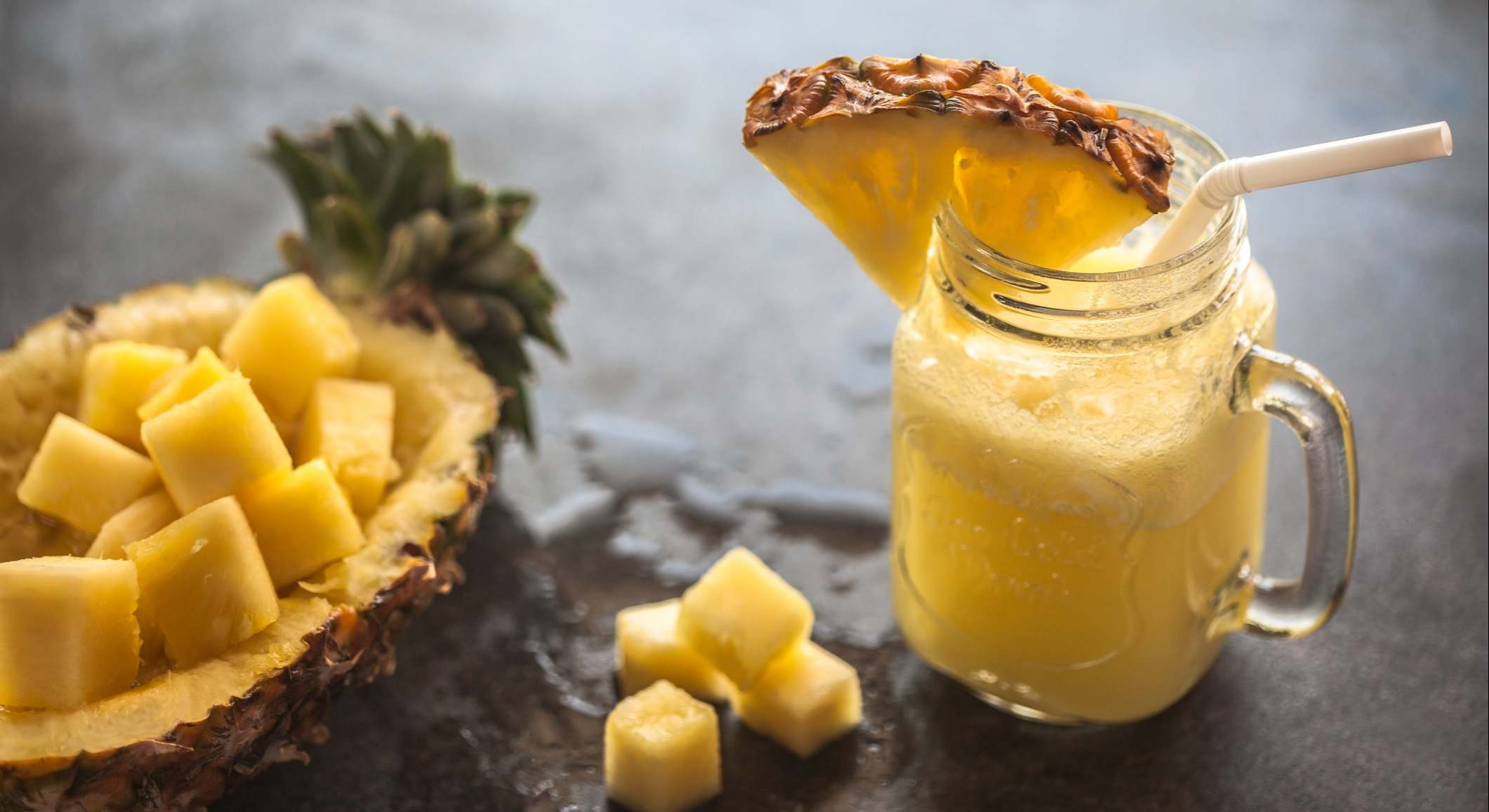 Zumo de frutas con una piña al lado