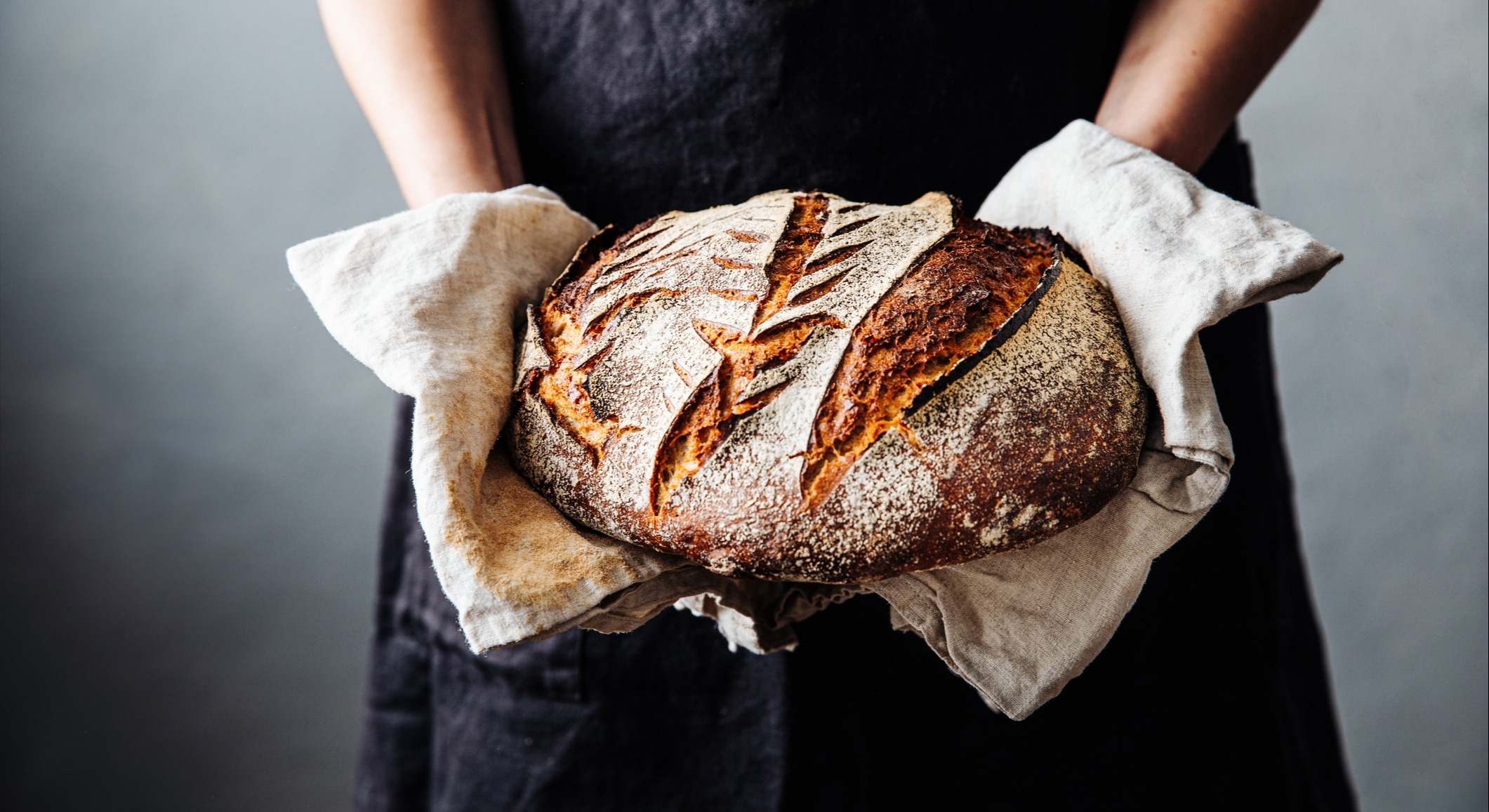 Una panadera sosteniendo un pan