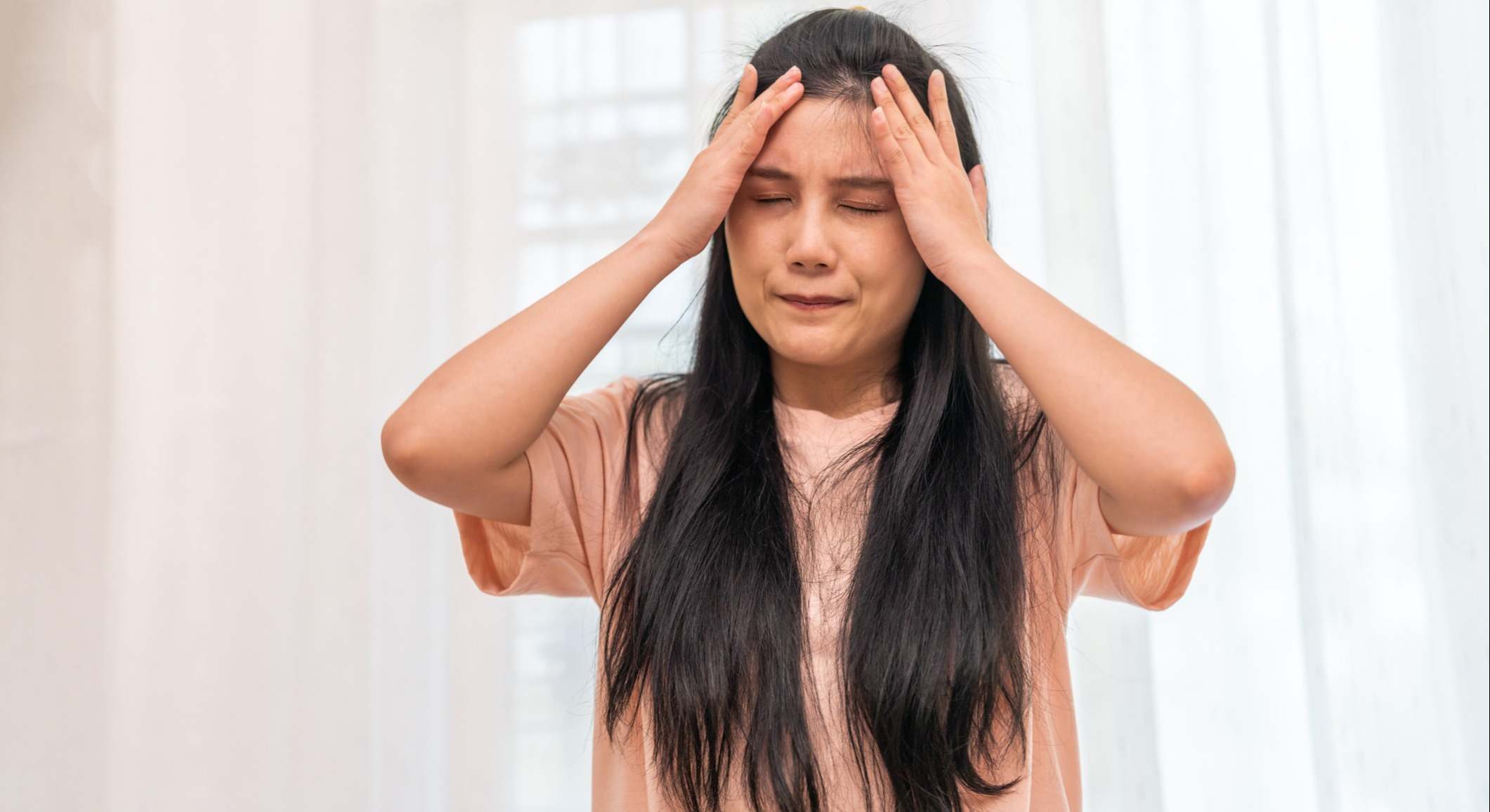 Mujer llevándose las manos a la cabeza