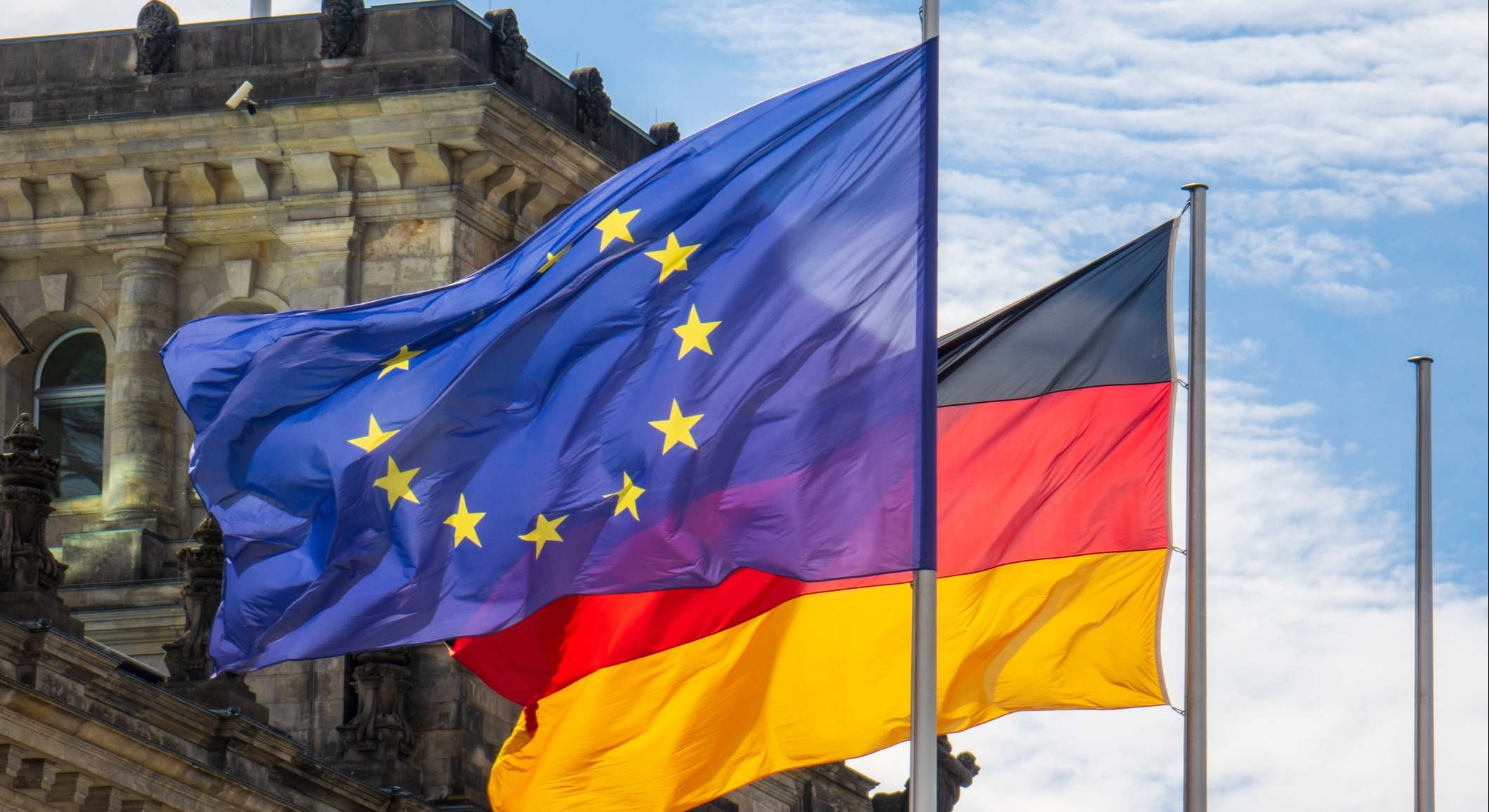 Una bandera alemana junto a la de la Unión Europea