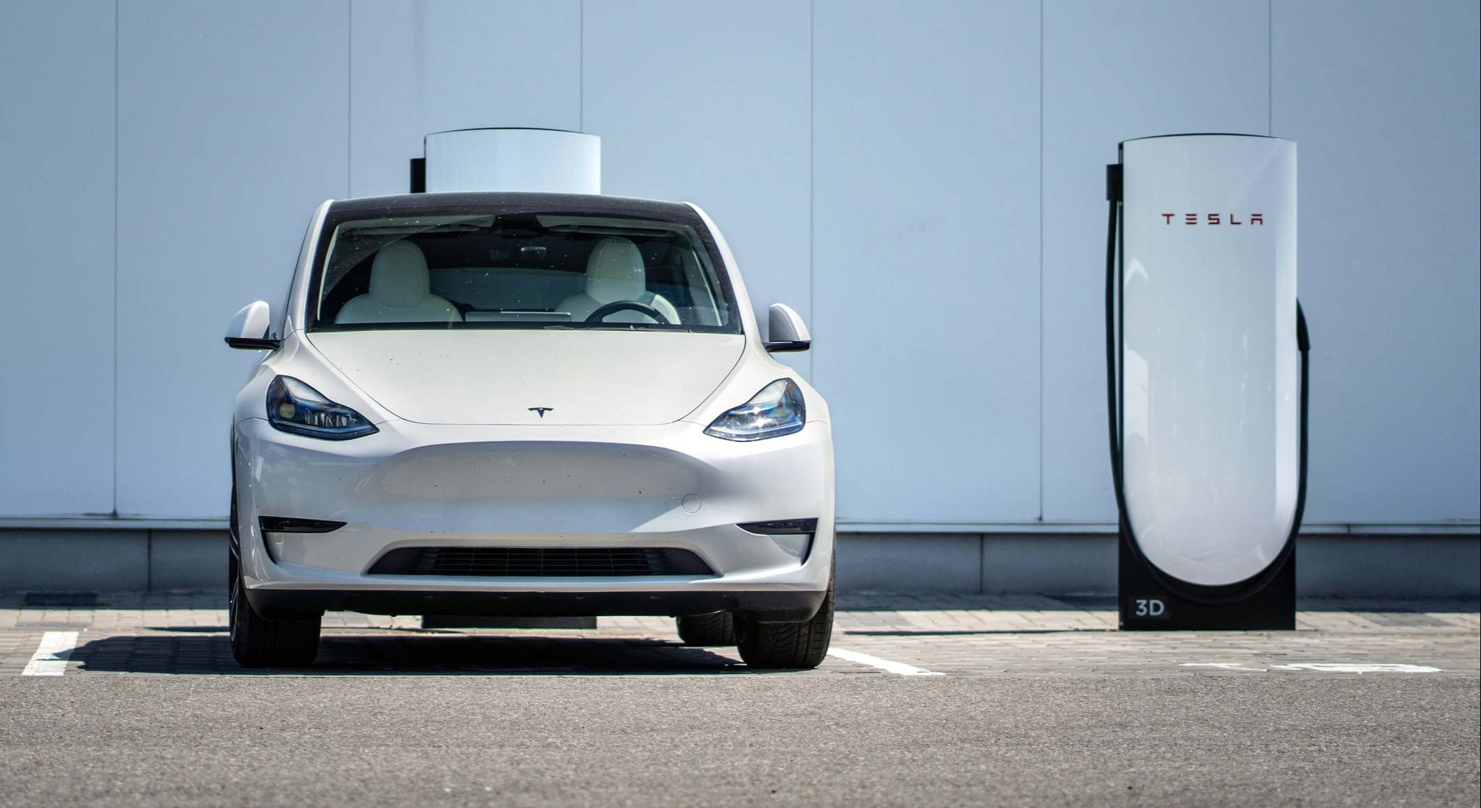 Tesla Model Y aparcado frente a una estación de carga | Tesla 
