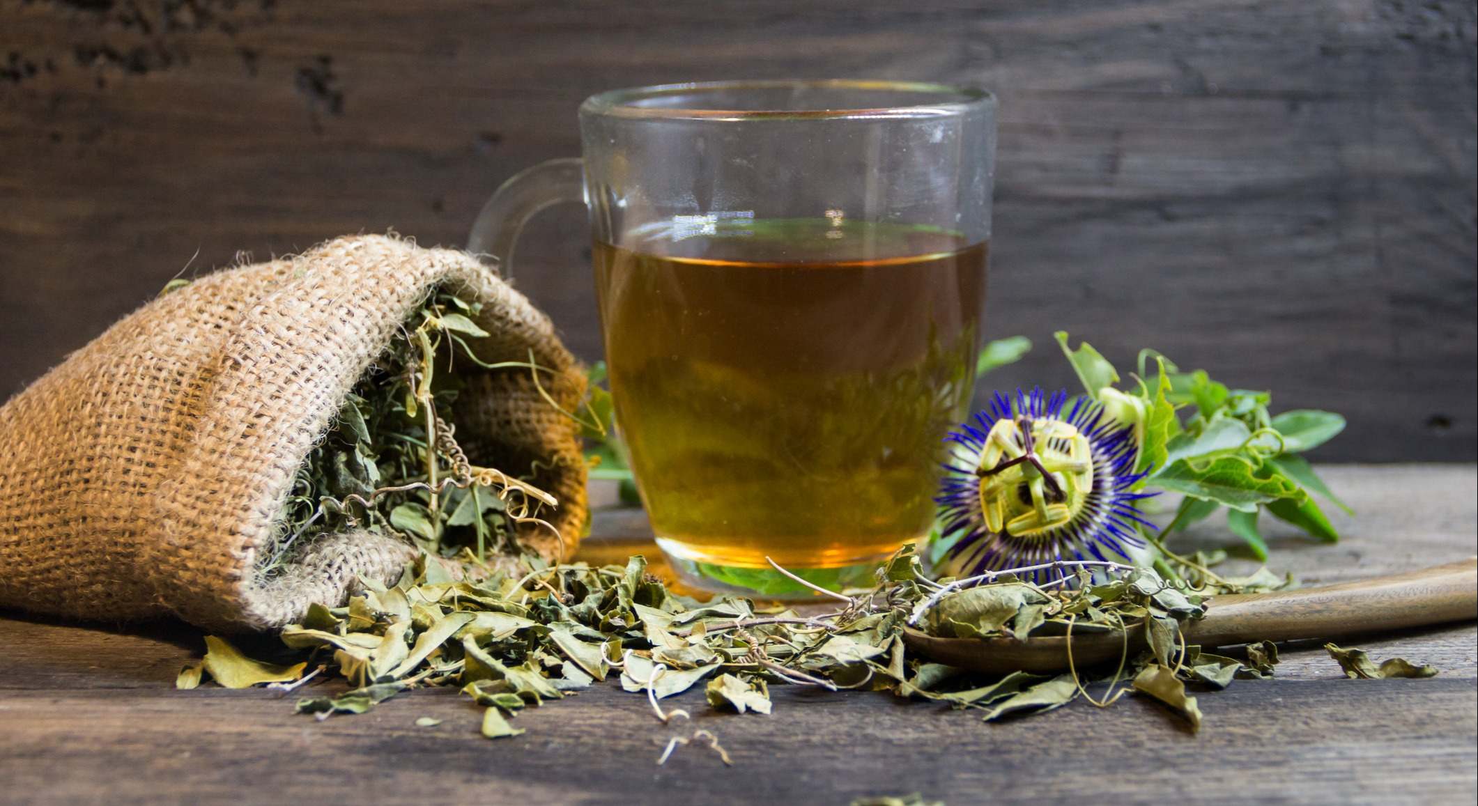 Flores secas y hojas de pasiflora al lado de una infusión