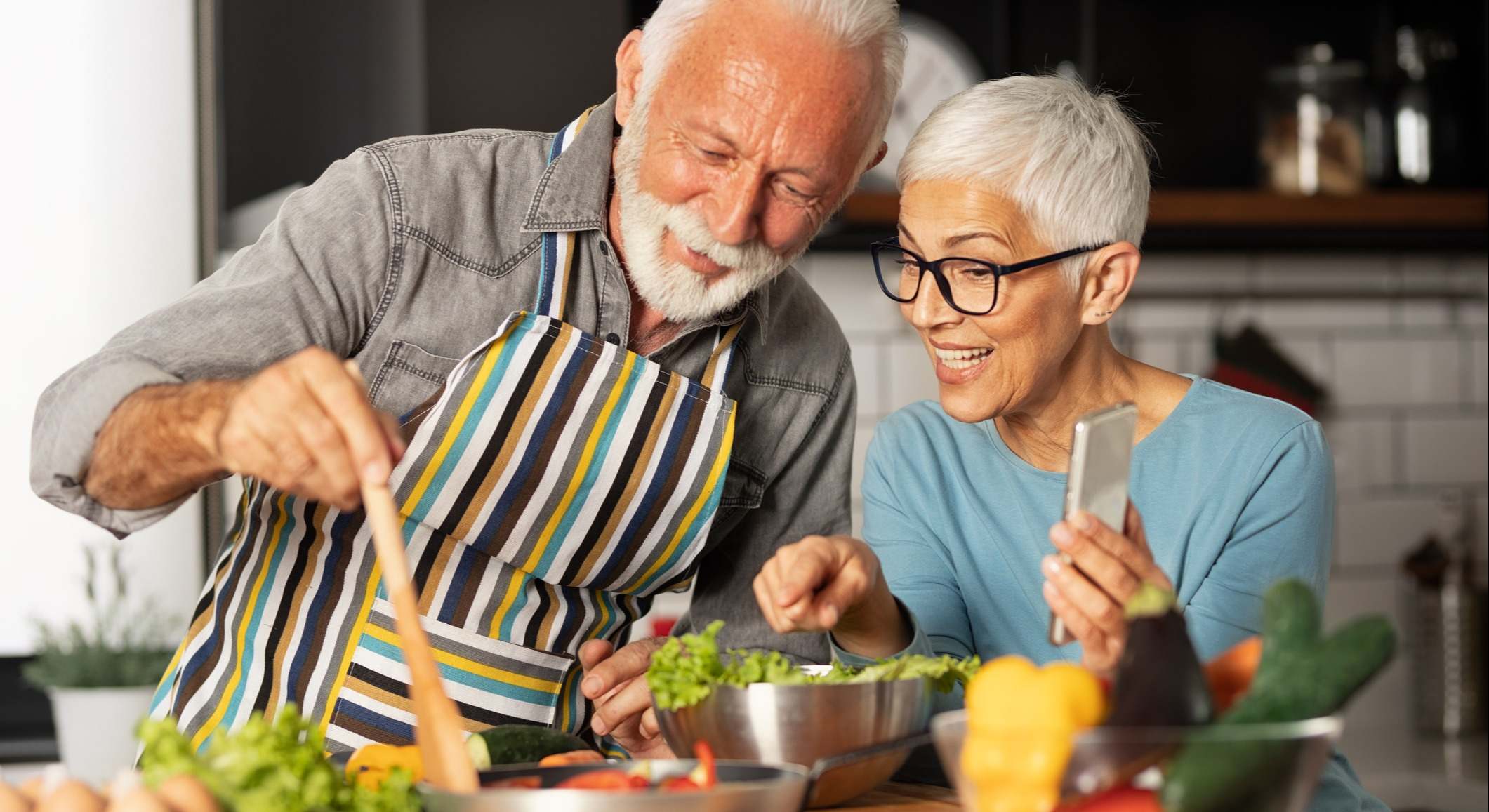 Pareja de la tercera edad preparando la comida