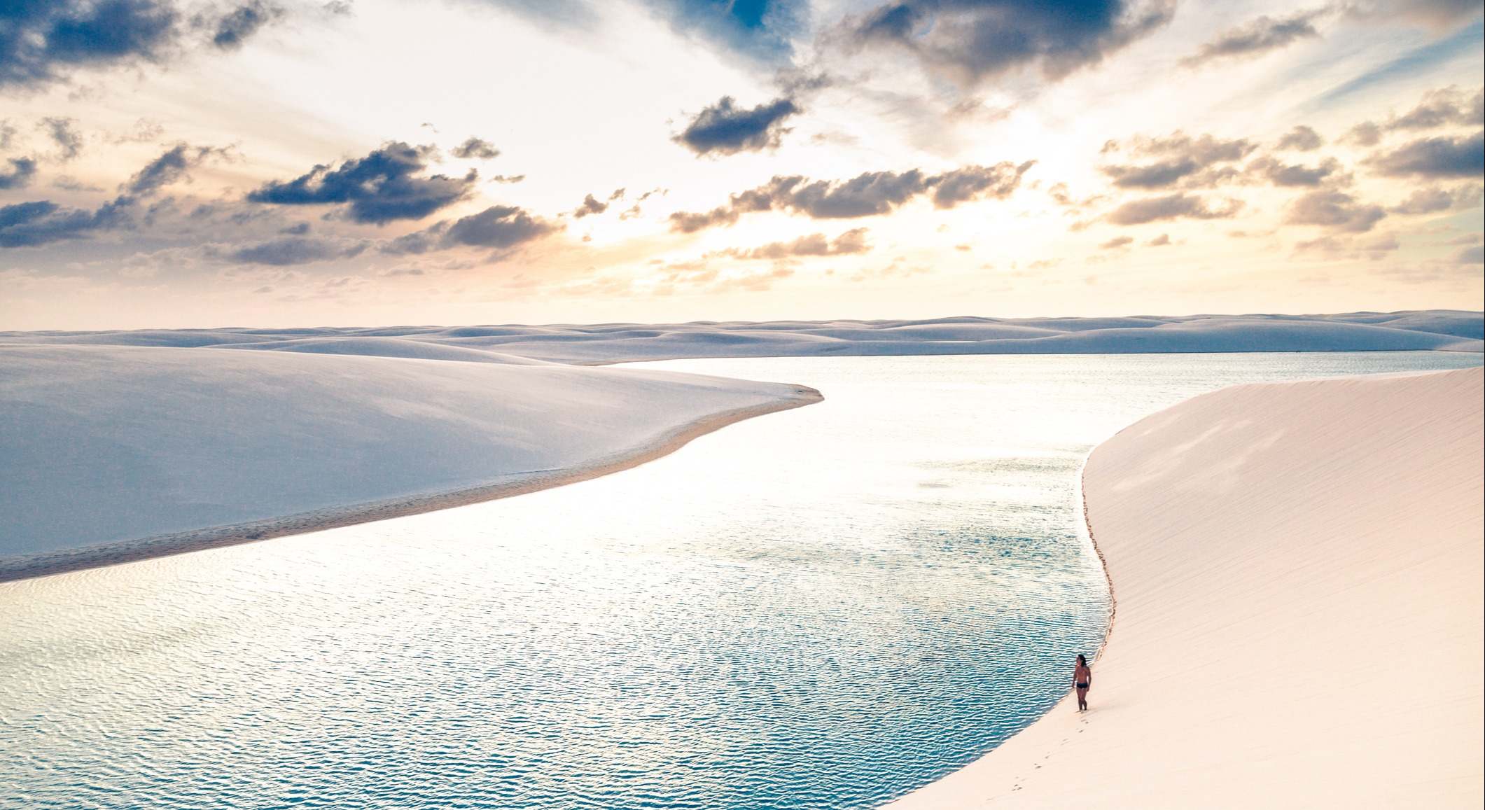Hombre caminando por las dunas de arena de Lençois Maranhenses