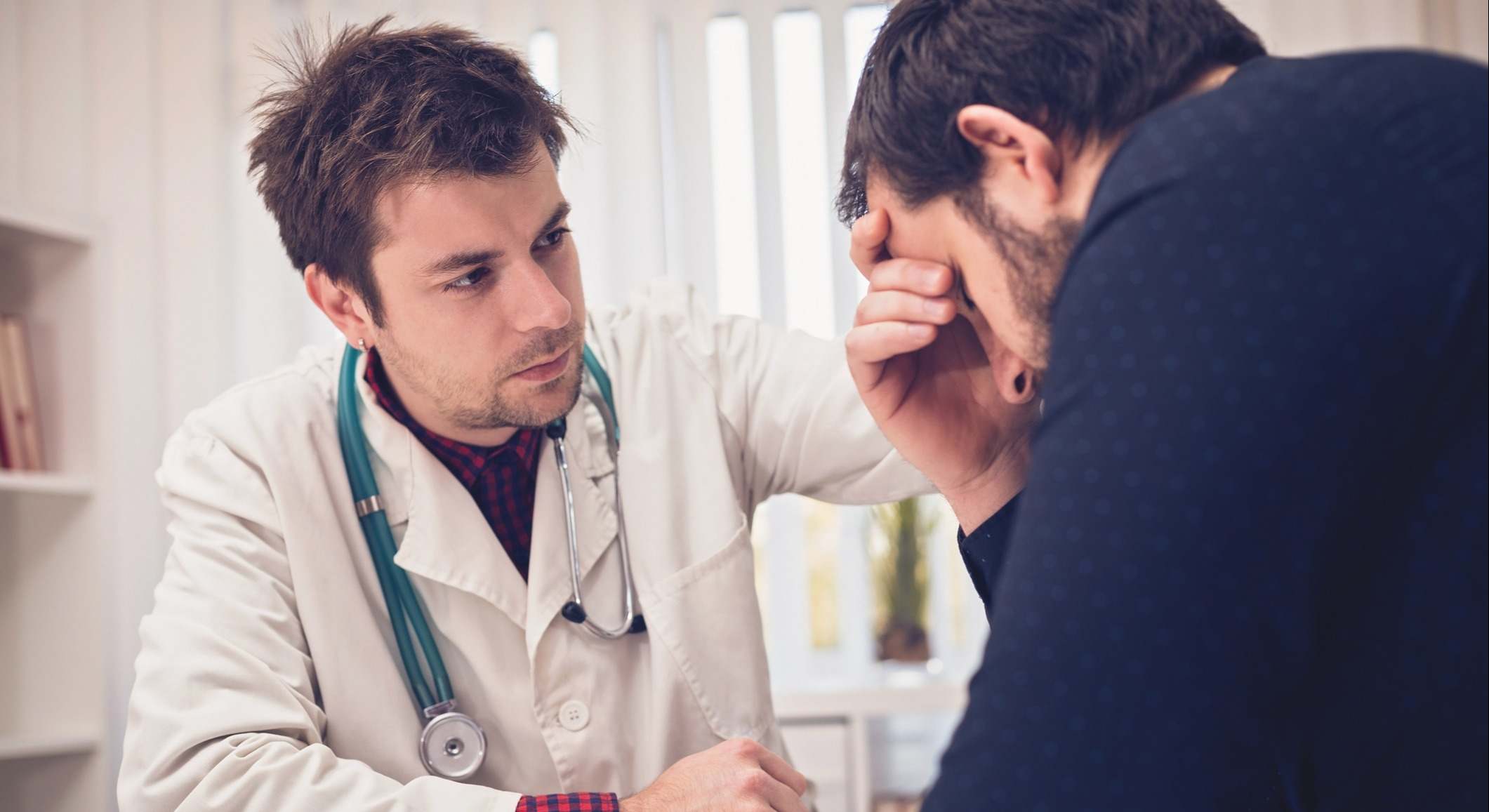 Doctor consolando a un paciente en la consulta