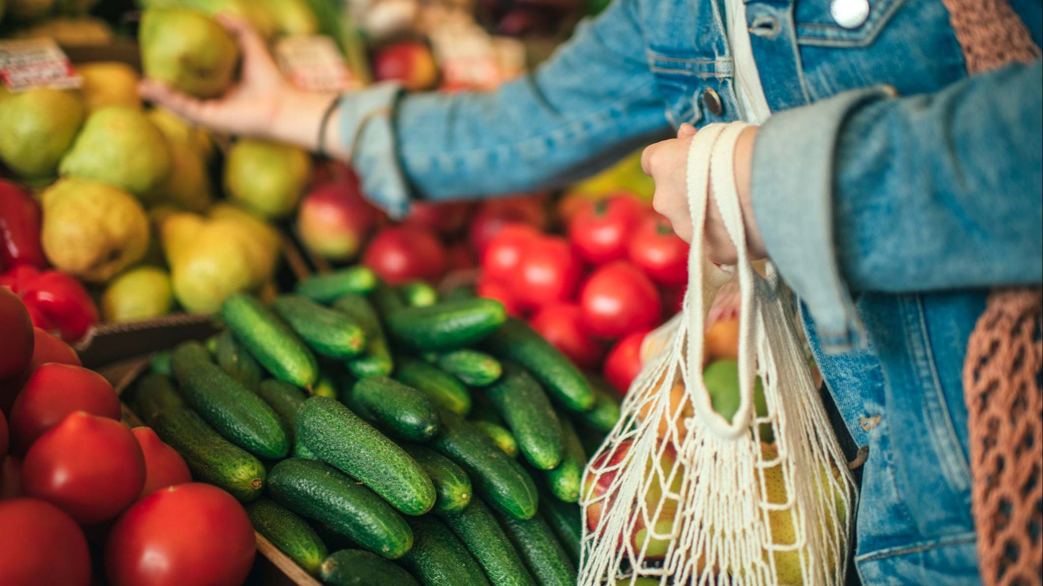 Personas comprando verduras y frutas en un mercado