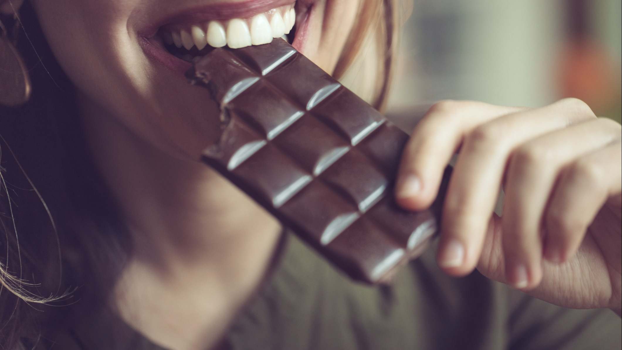 Mujer comiendo una tableta de chocolate