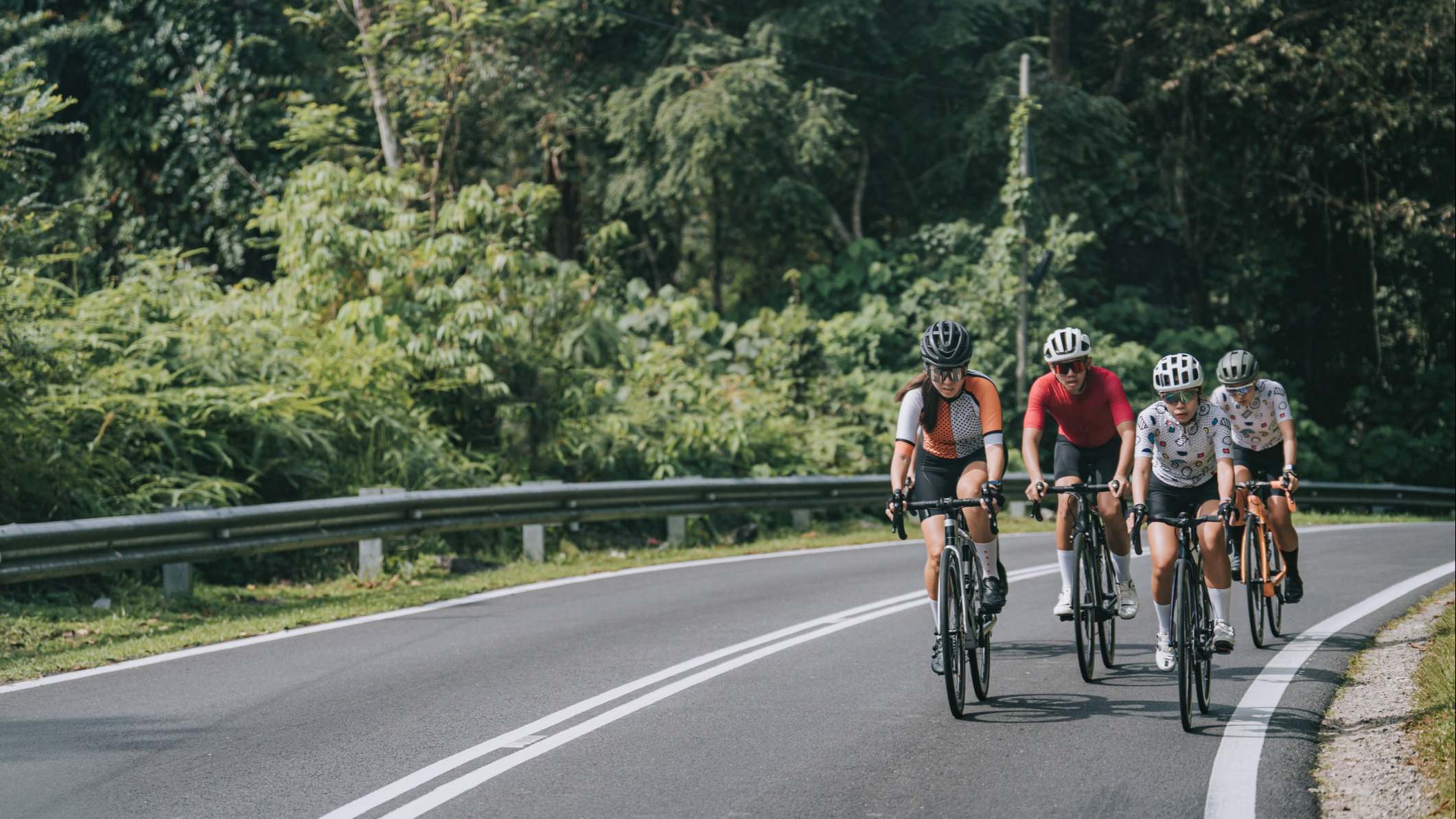 Grupo de ciclistas por una carretera con línea continua