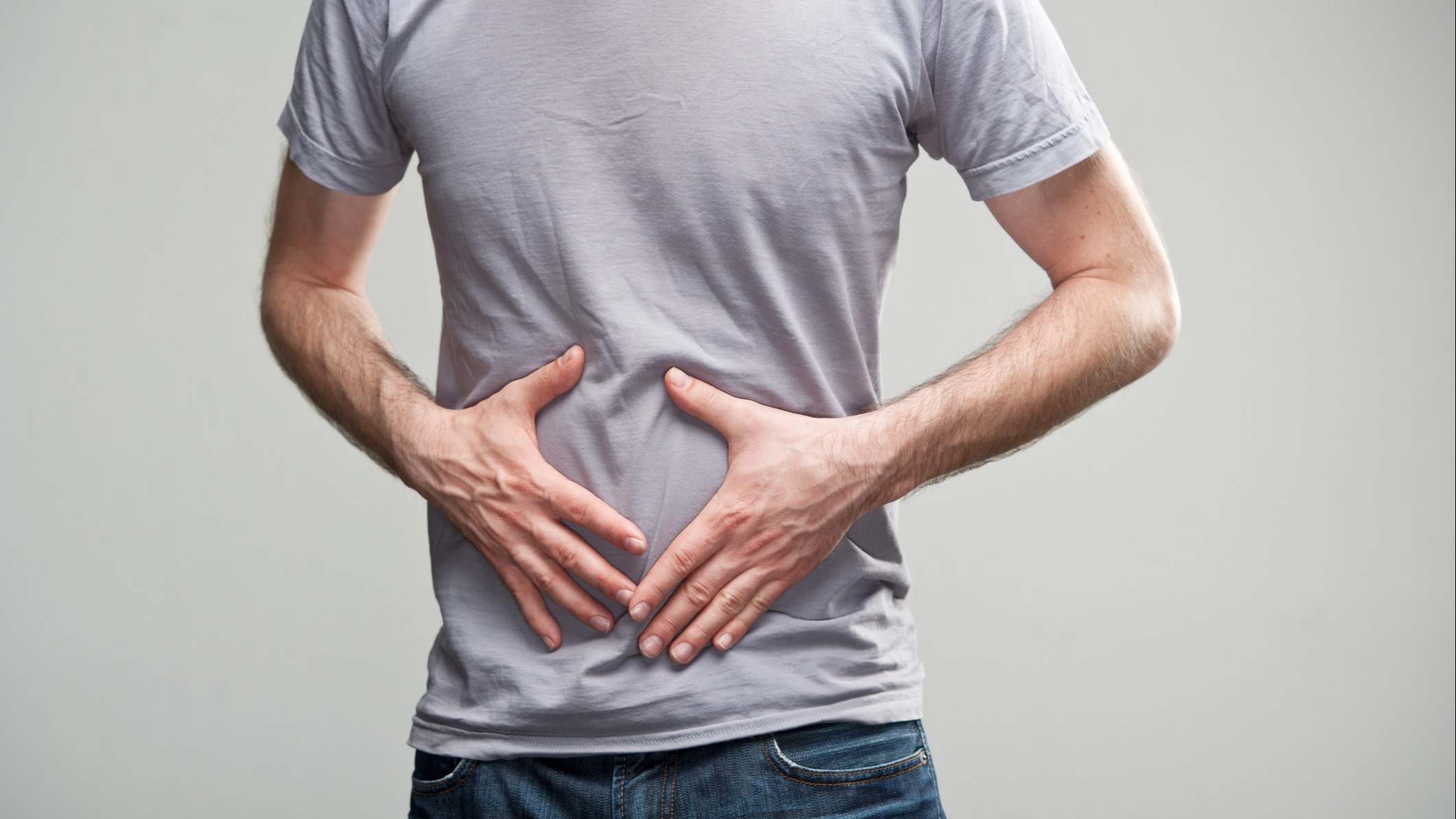 Hombre se toca el estómago en señal de dolor de estómago