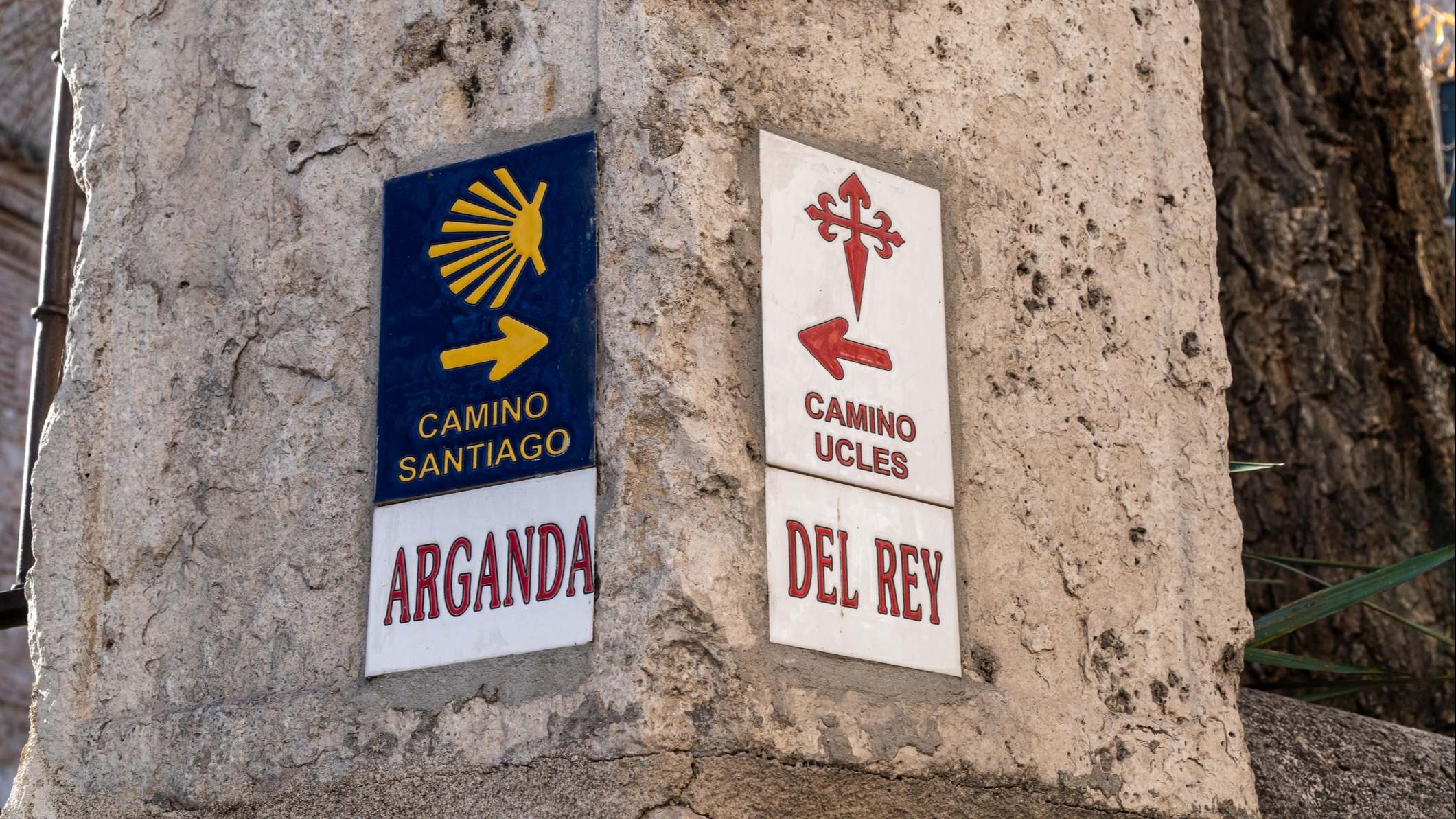 Señales con las flechas direccionales del Camino de Santiago y el Camino de Uclés sobre una columna de piedra en Arganda del Rey en Madrid, España
