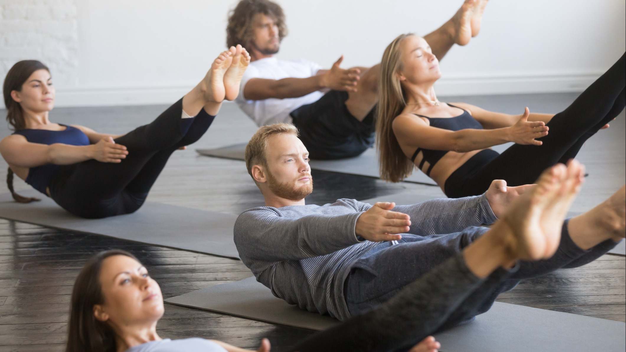 Grupo de personas realizando ejercicios abdominales en una clase