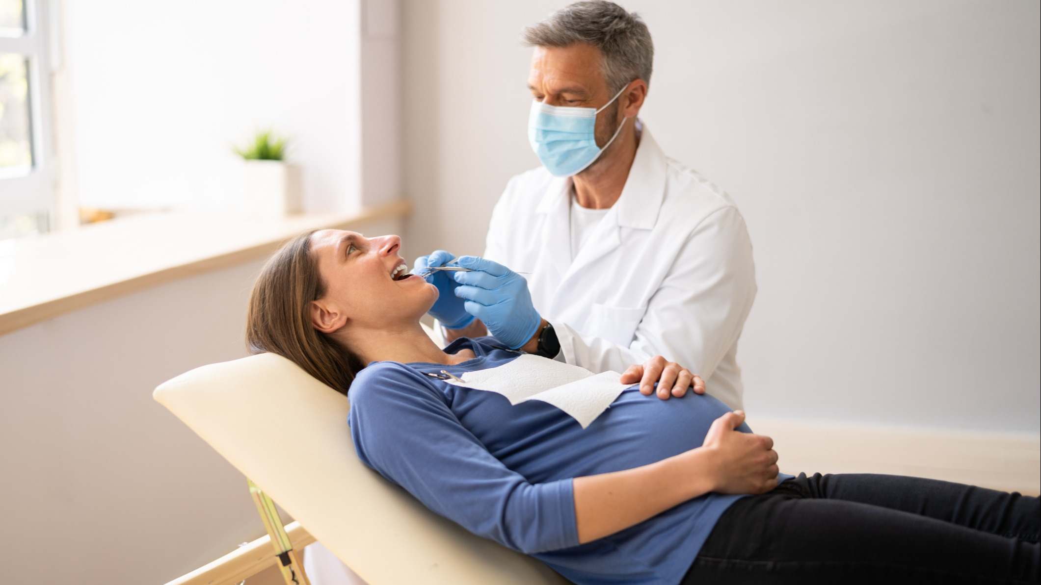 Dentista que trata los dientes de una joven embarazada