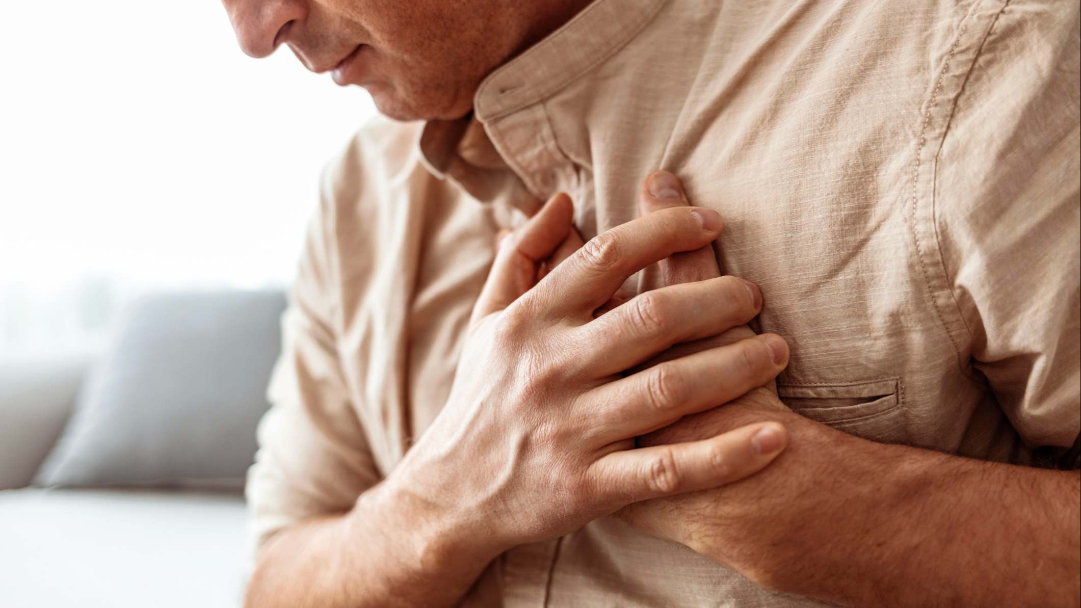 Hombre con problemas en el corazón llevándose las manos al pecho