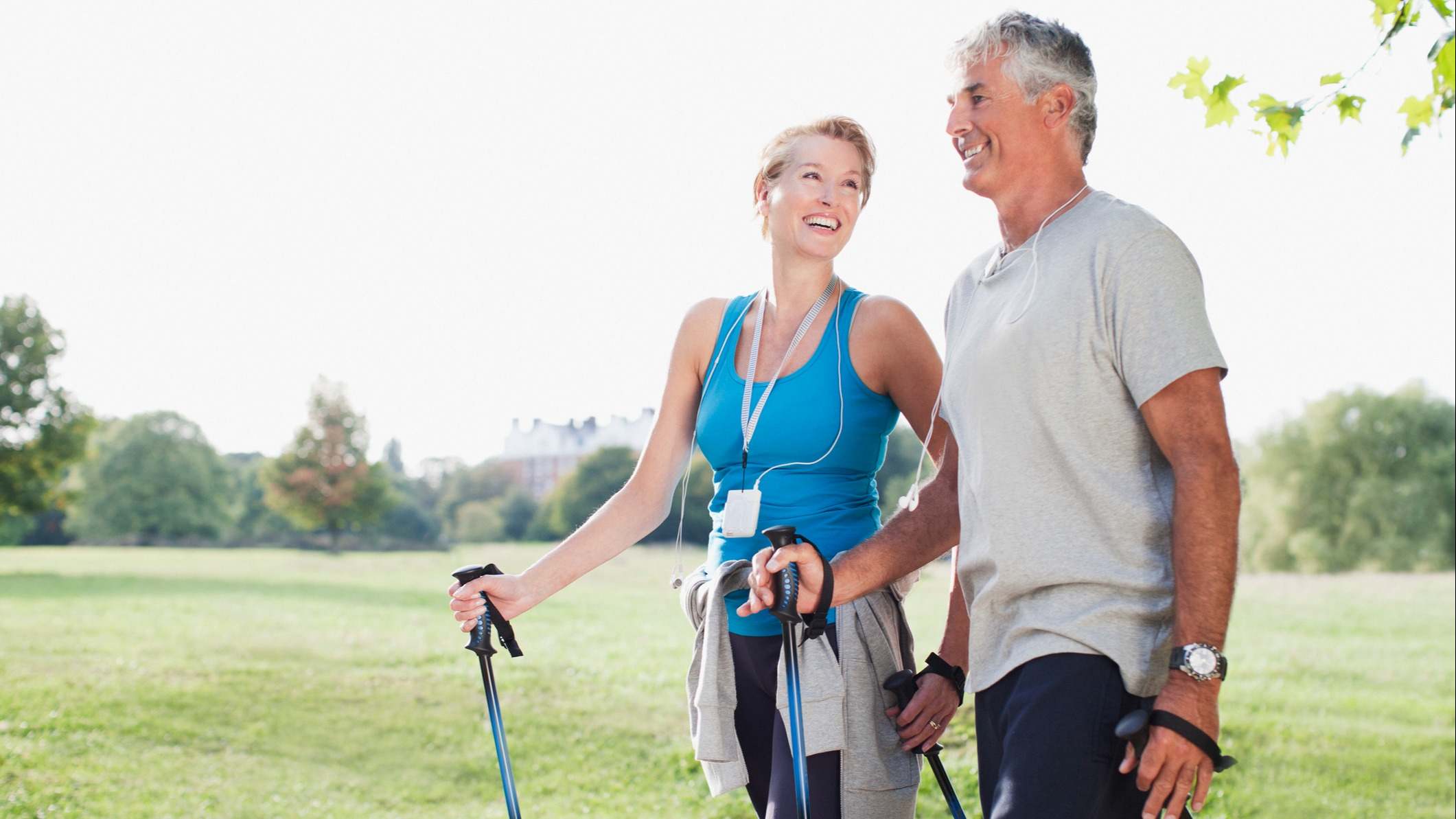 Pareja de personas mayores de 50 años caminando por la naturaleza