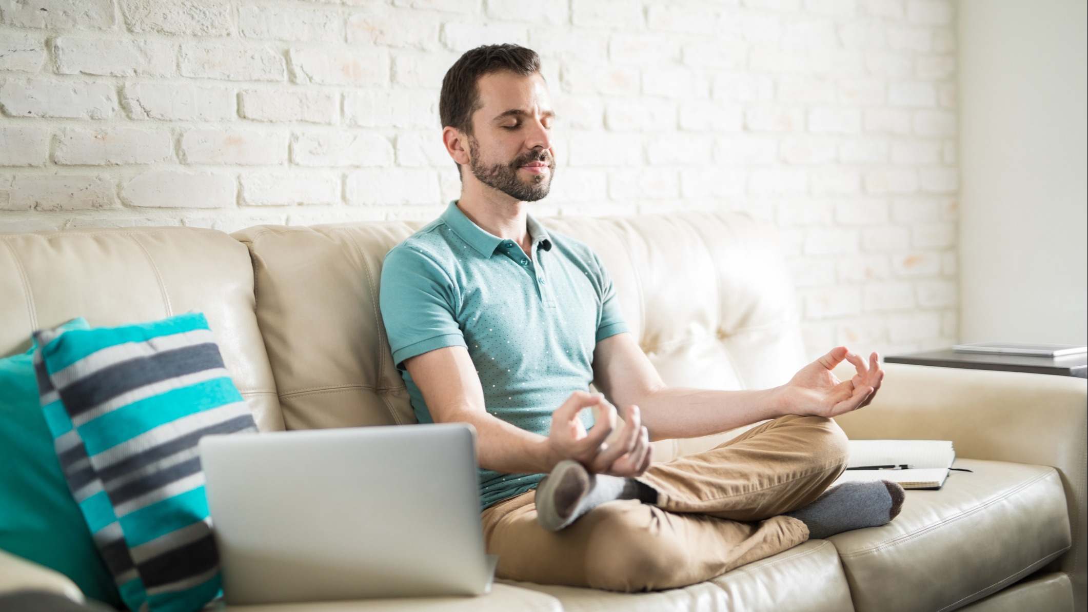 Hombre meditando en un sofá durante un descanso de trabajo