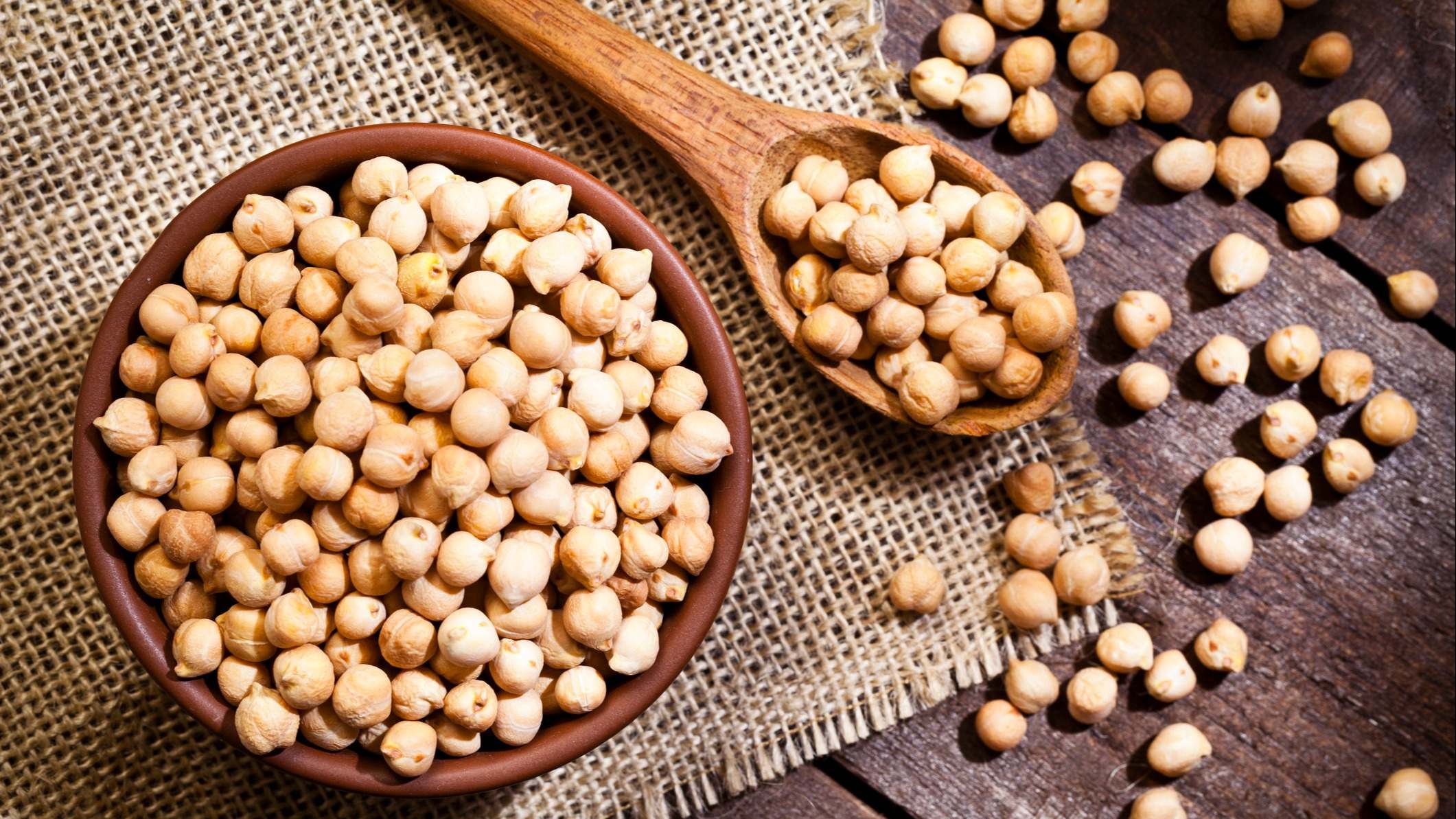 Garbanzos secos en un tazón en una mesa de madera