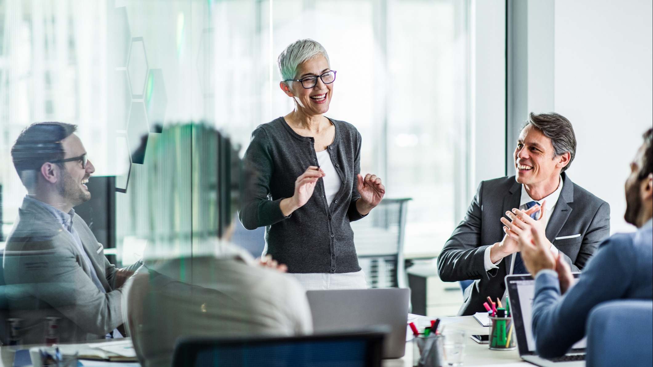 Mujer siendo aplaudida en una reunión de negocios exitosa