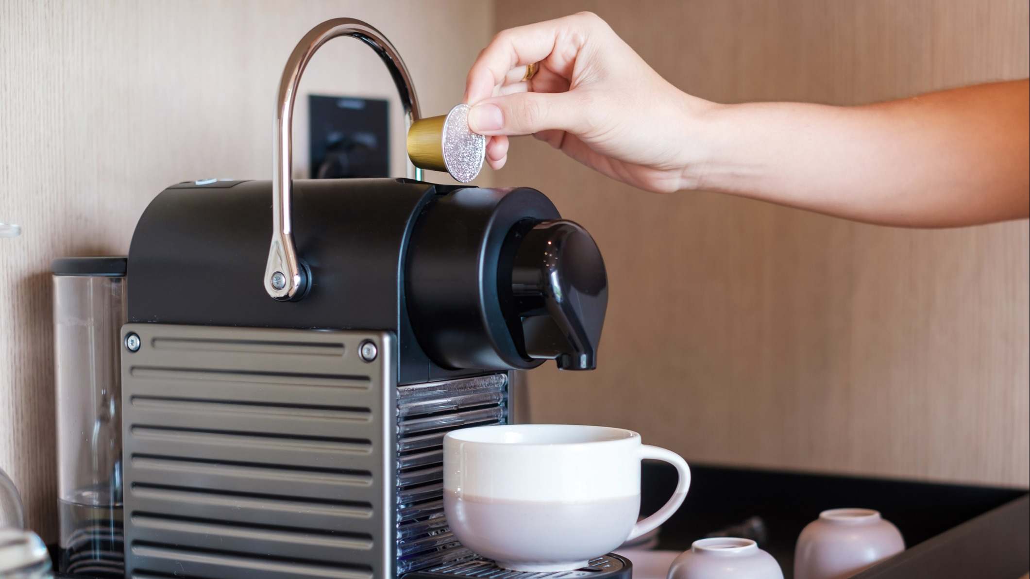 Cafetera de cápsulas sobre una mesa de madera
