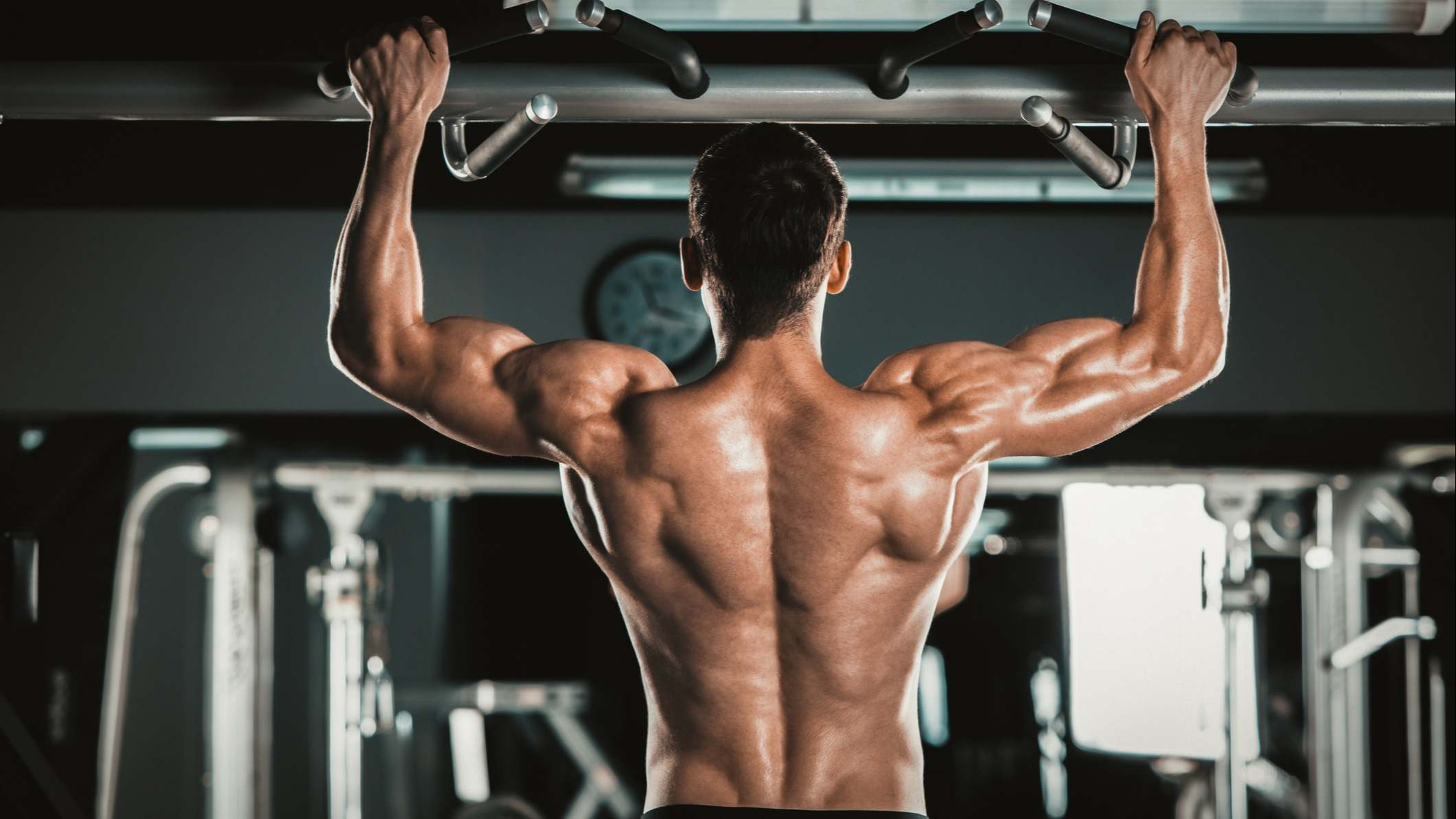 Hombre realizando dominadas en el gimnasio