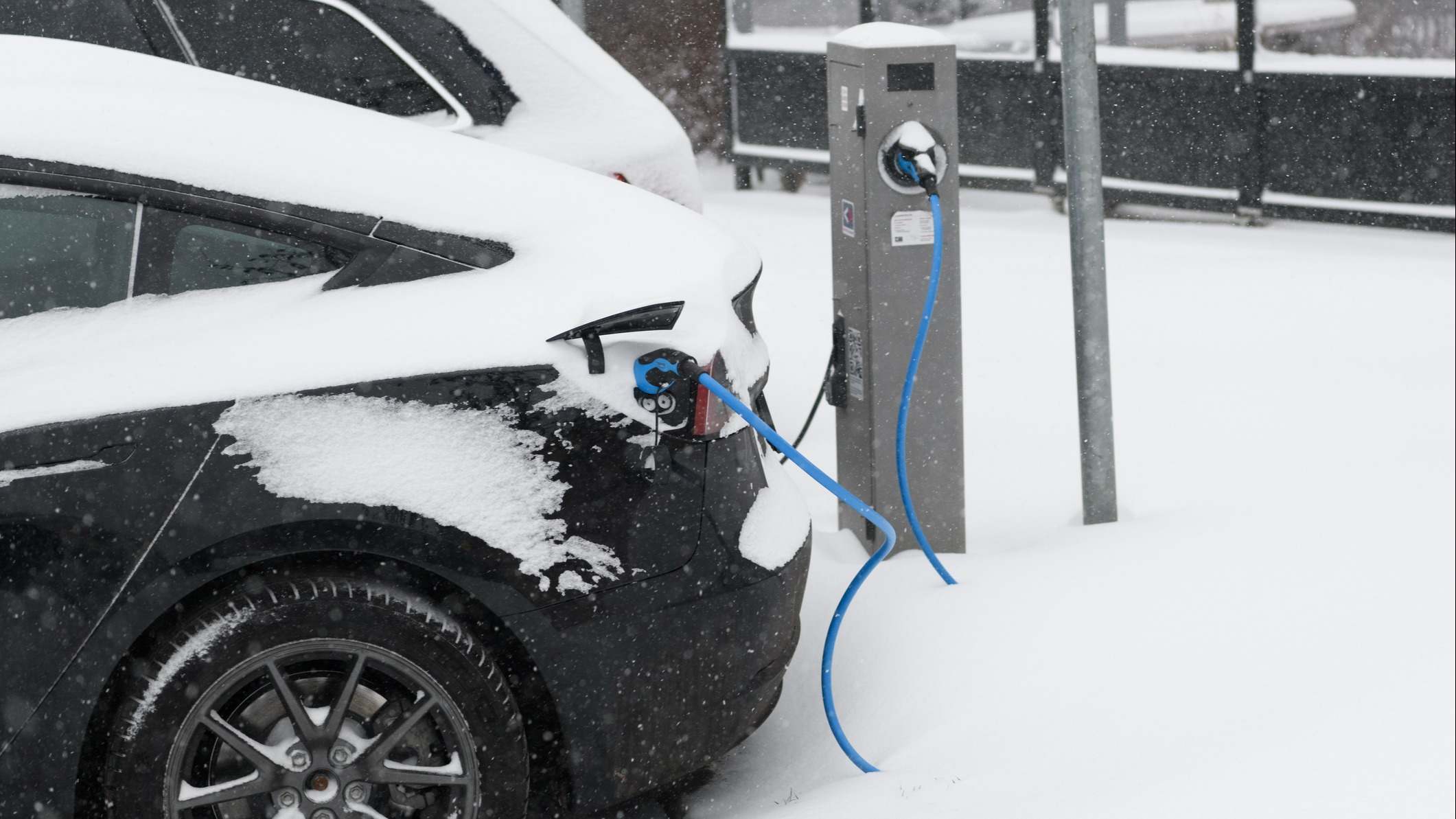 Coche eléctrico cargando con nieve a su alrededor