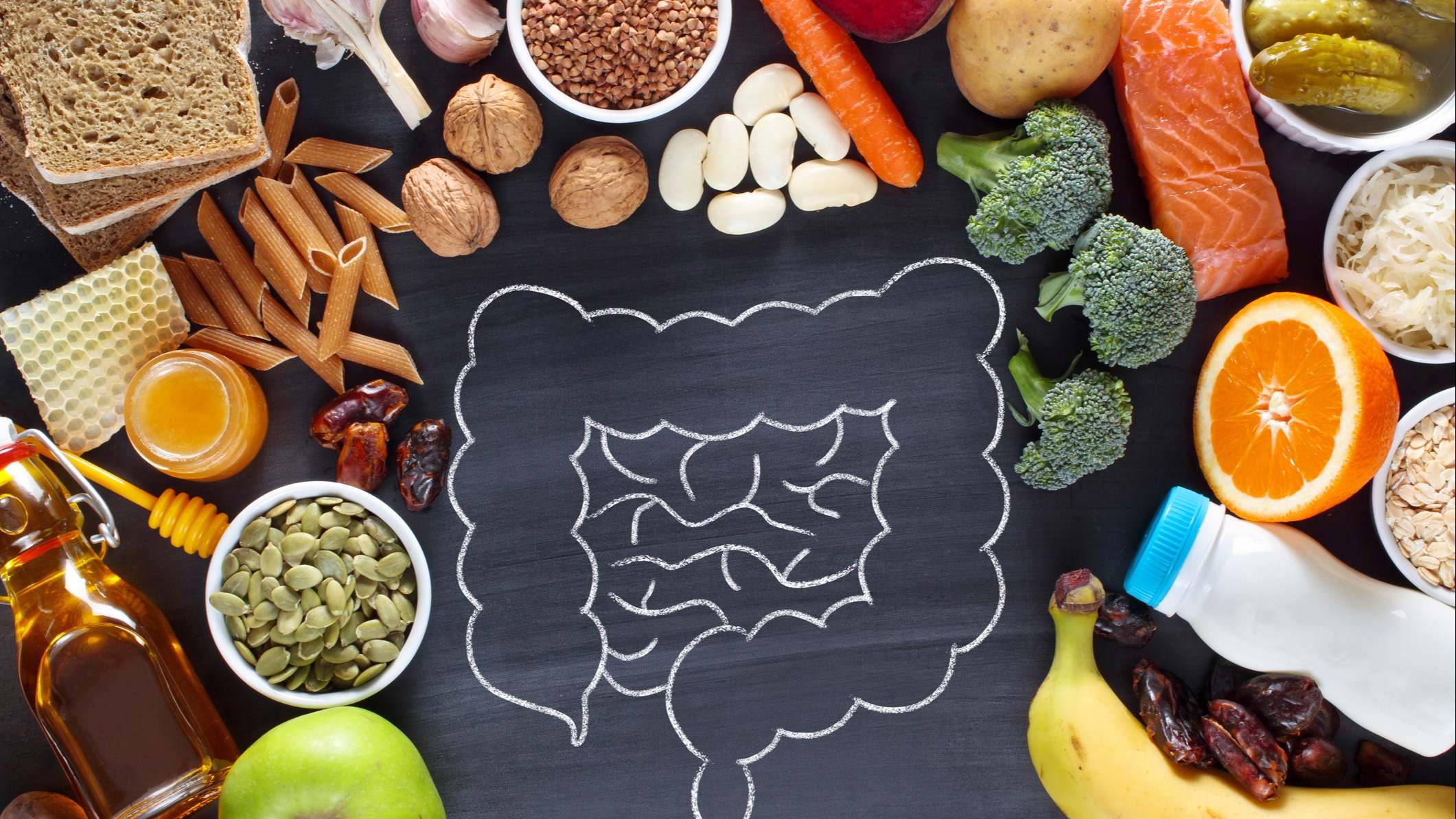 Alimentos rodeando un dibujo de un intestino sobre una pizarra