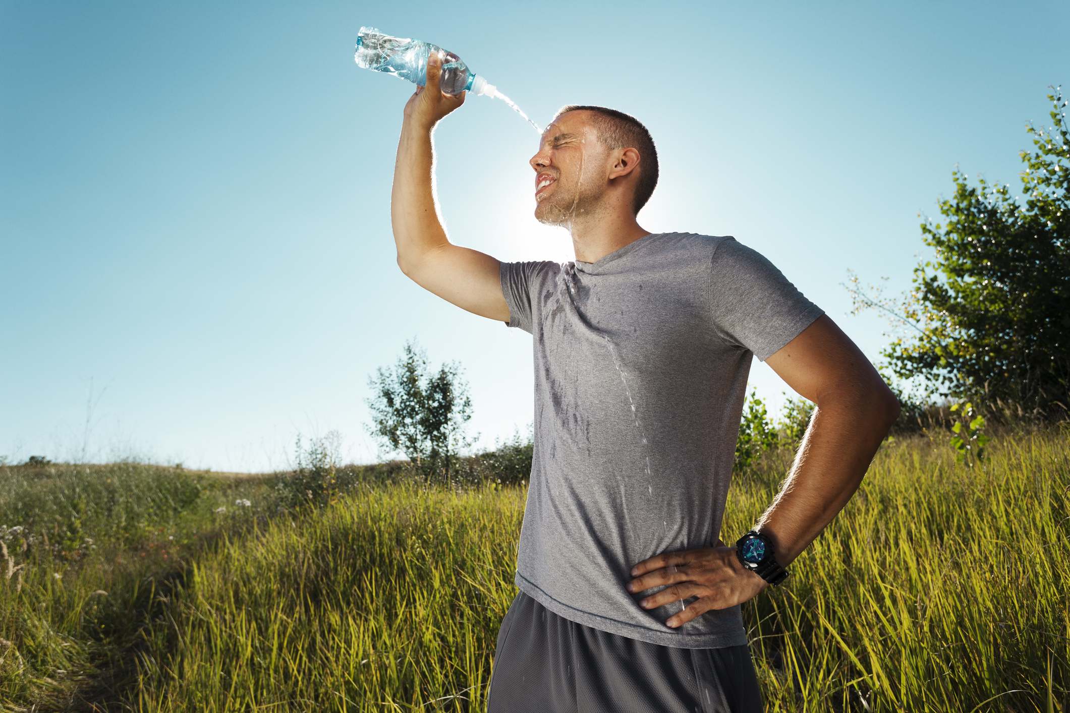 Un hombre se echa agua por encima después de entrenar.