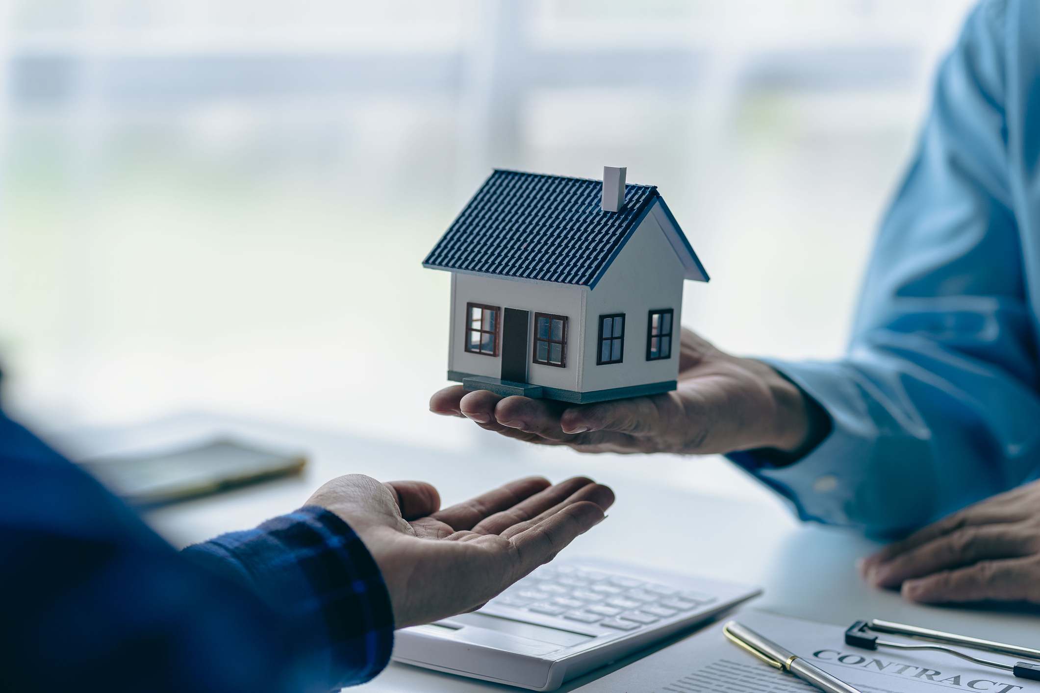 Dos personas firmando un contrato de compraventa de vivienda