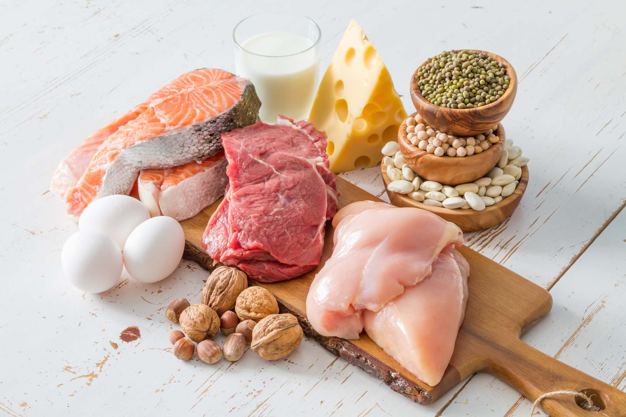 Alimentos ricos en proteínas sobre una tabla de madera encima de una mesa