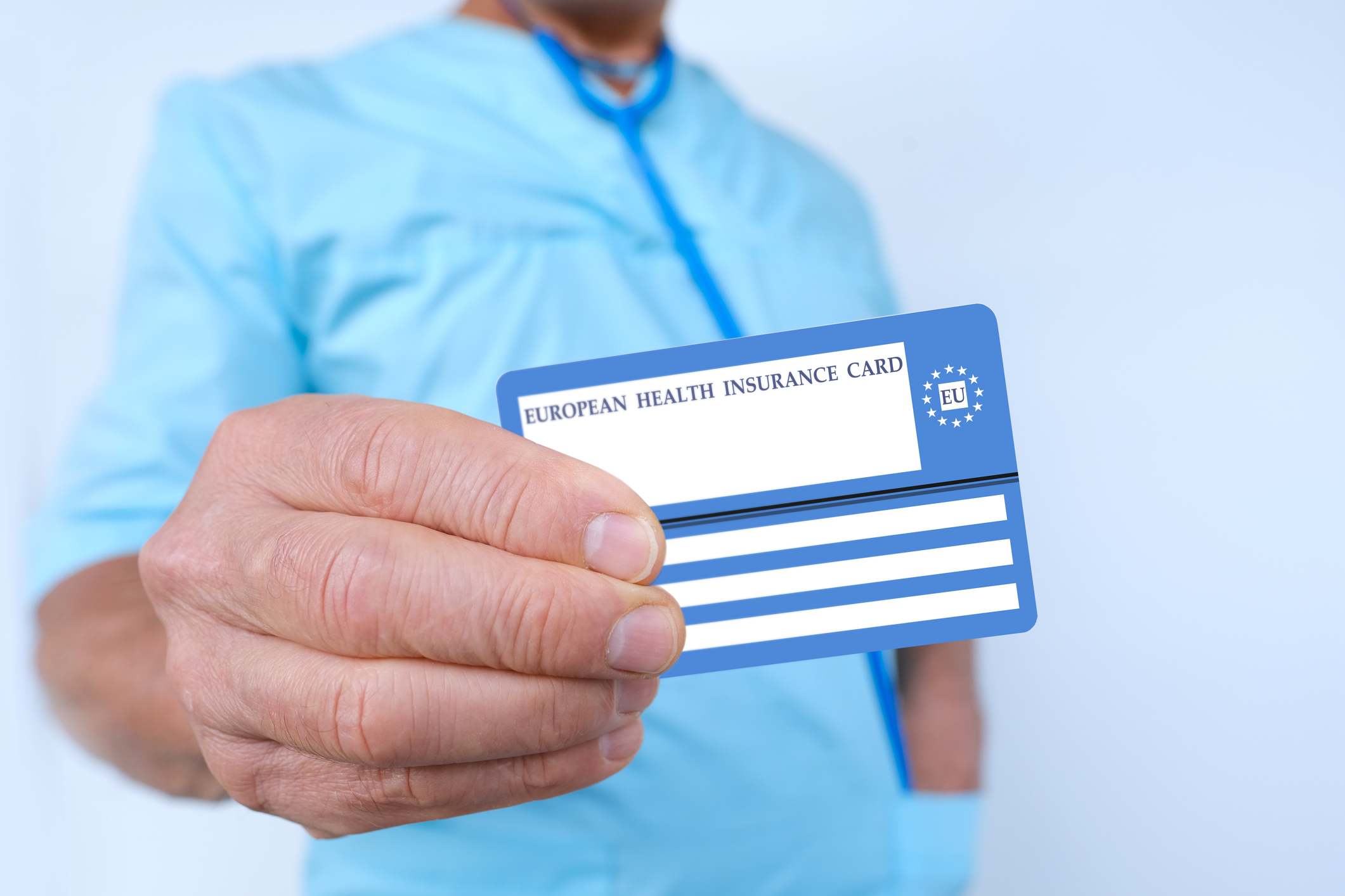 Doctor sosteniendo en un primer plano una Tarjeta Sanitaria Europea