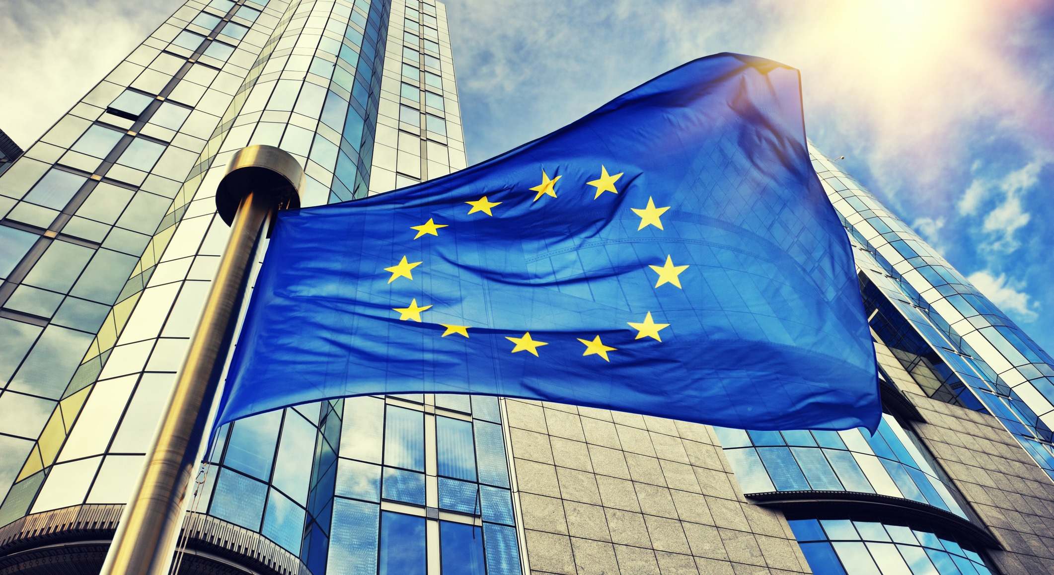 Bandera de la UE ondeando frente al edificio del Parlamento Europeo en Bruselas