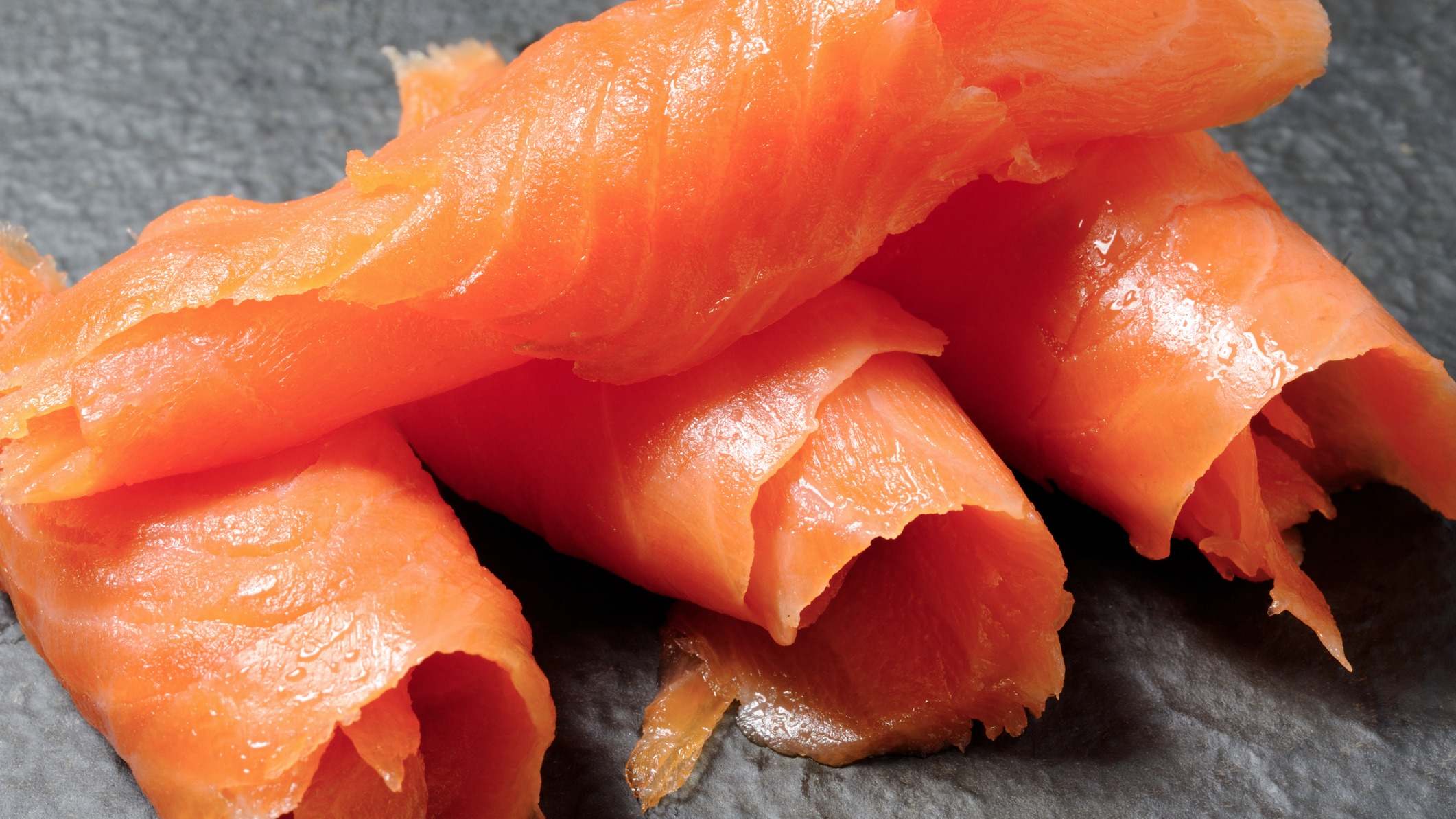 Piezas de salmón ahumado sobre una tabla de pizarra