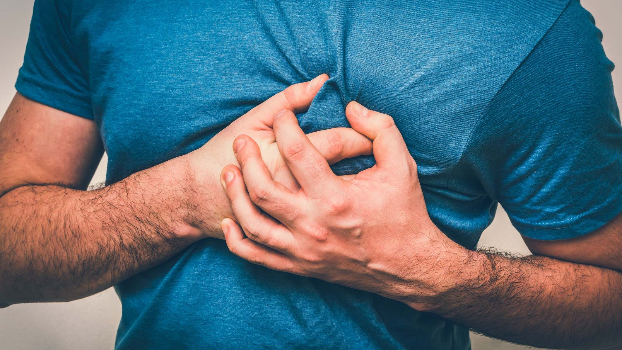 Hombre se agarra fuertemente el pecho por el dolor