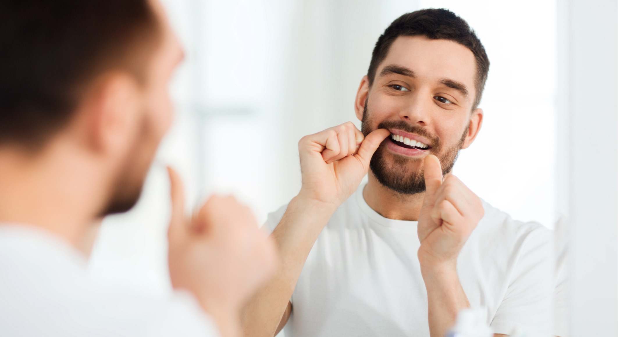 Hombre usa hilo dental