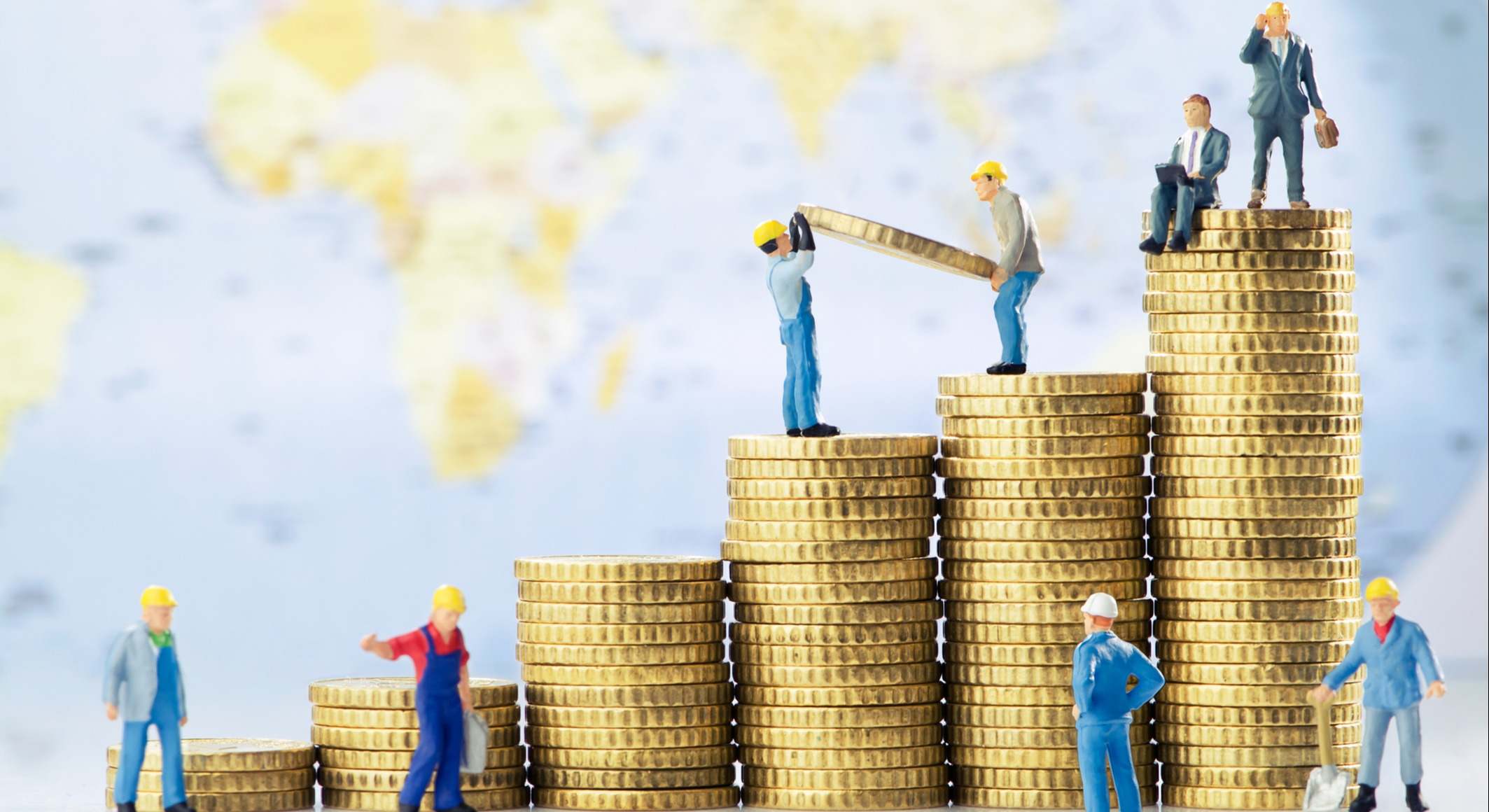 Trabajadores sobre montones de dinero.
