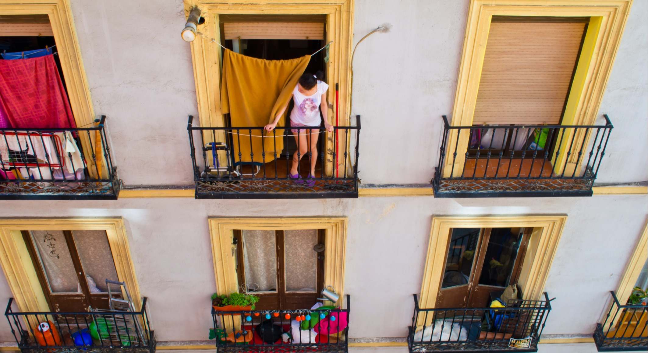Mujer en un balcón en un piso de Madrid. Foto: iStock