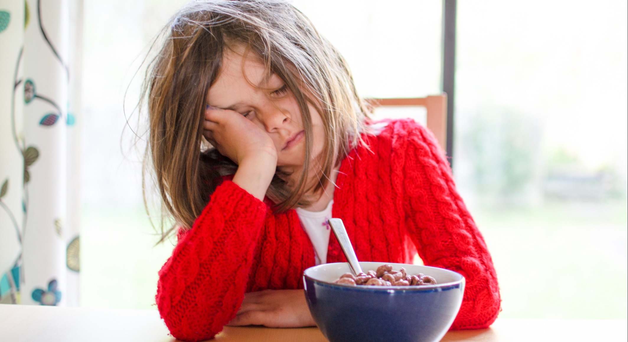 Niña quedándose dormida mientras desayuna