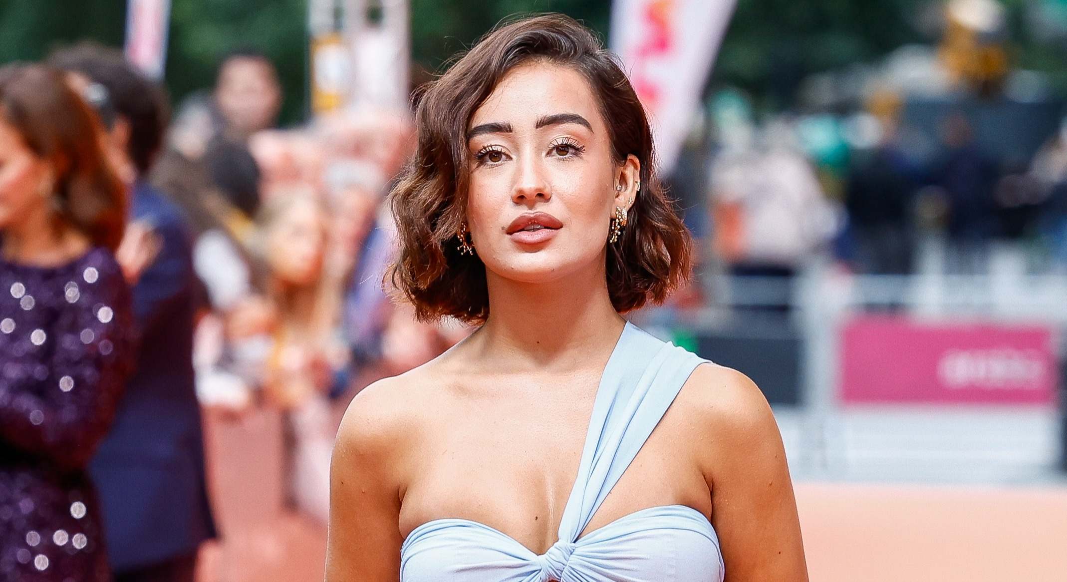 Marina Rivers con un vestido gris azulado con un solo tirante