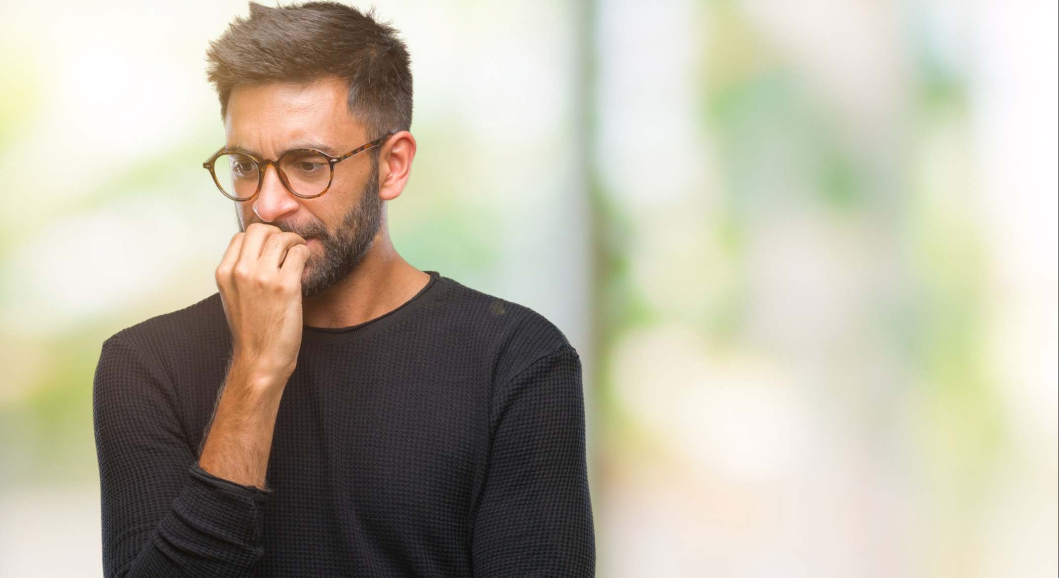 Hombre agobiado mordiéndose las uñas