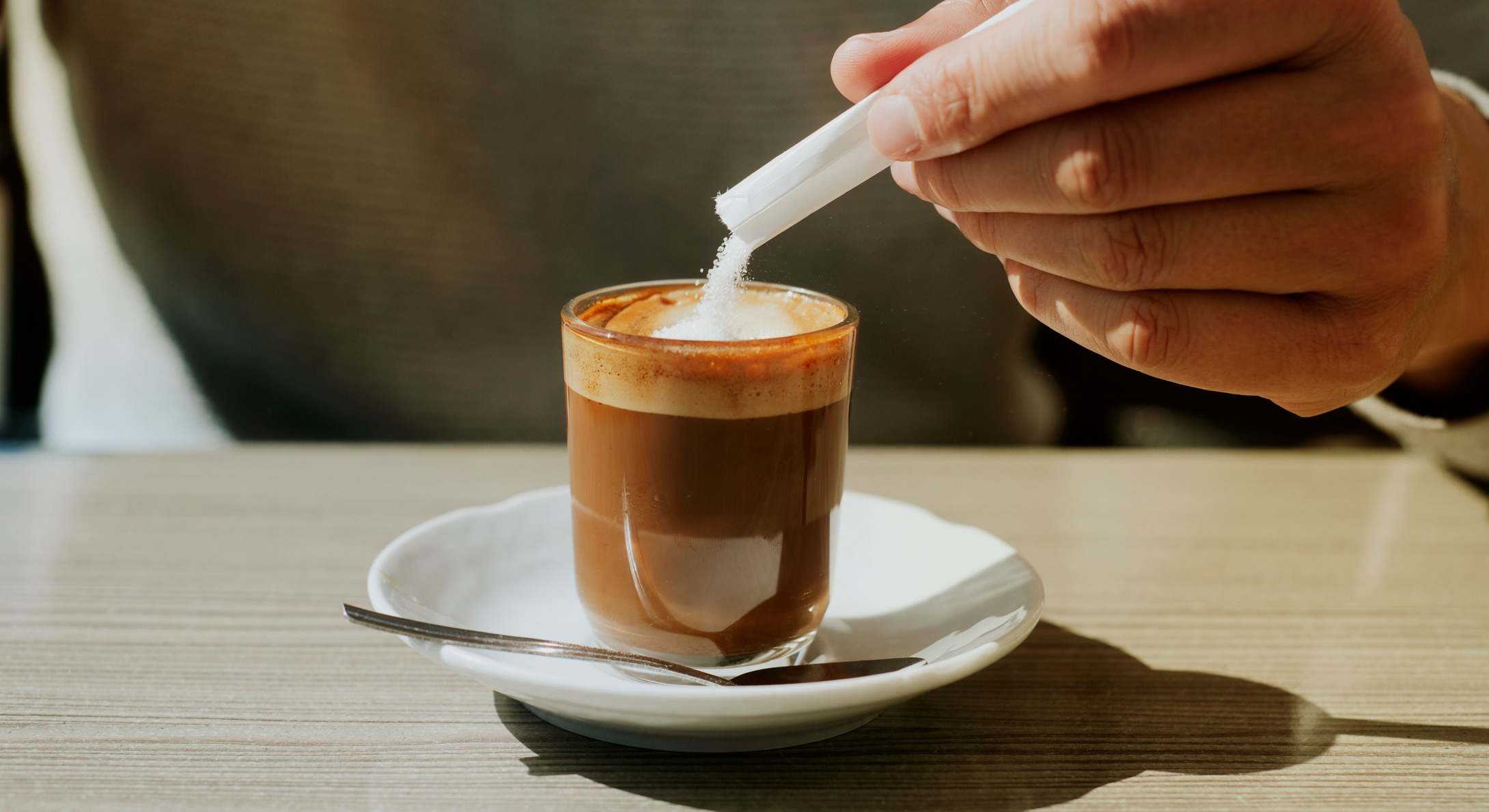 Persona añade azúcar a su café