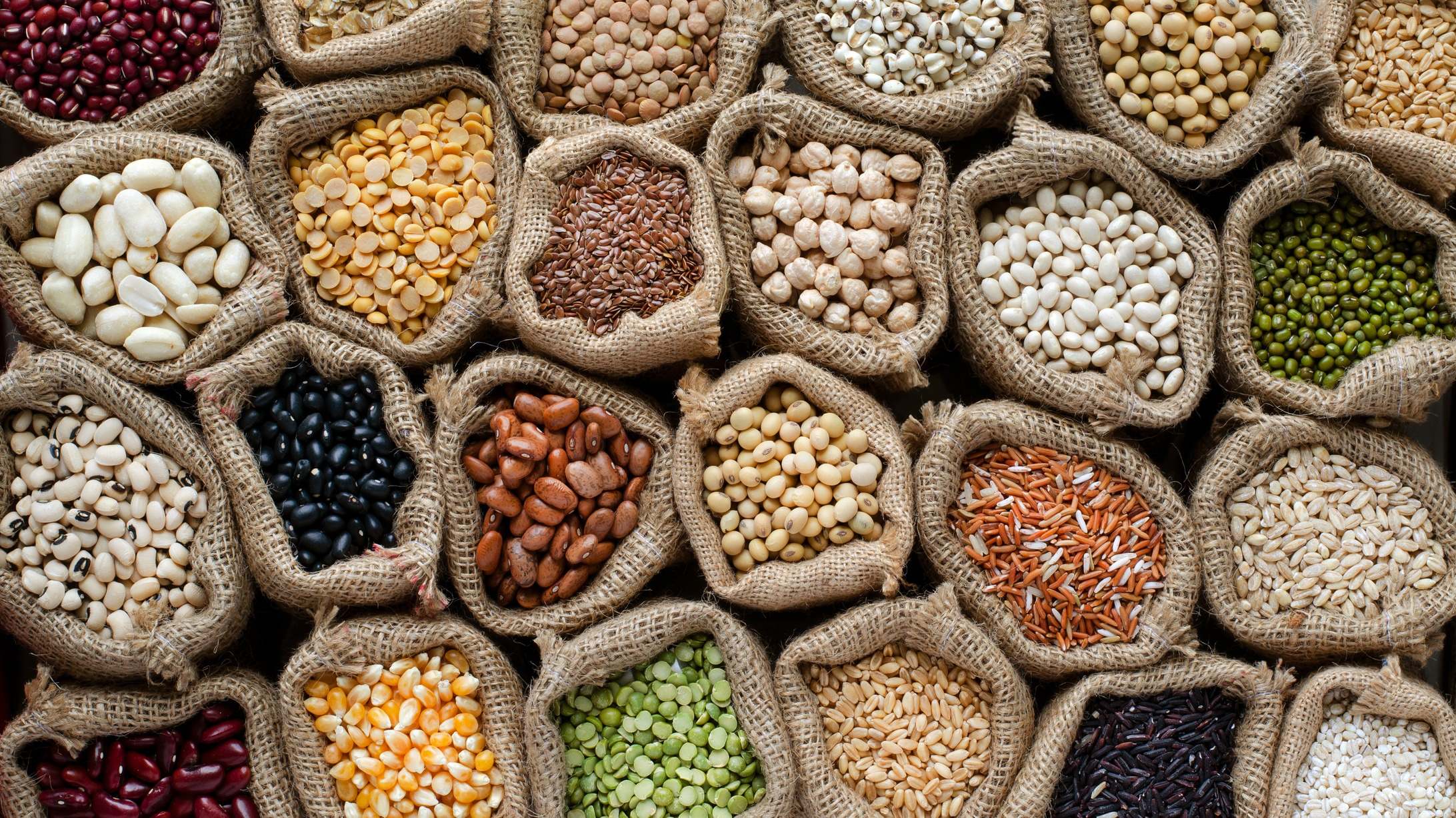 Variedad de tipos de cereales naturales y semillas de grano en saco
