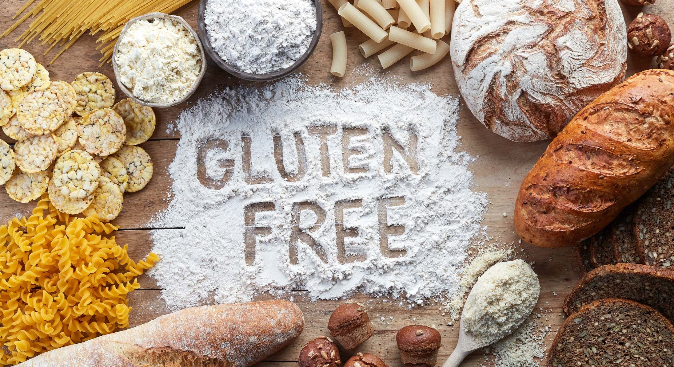 Pasta, pan, harina y dulces sin gluten sobre un madera