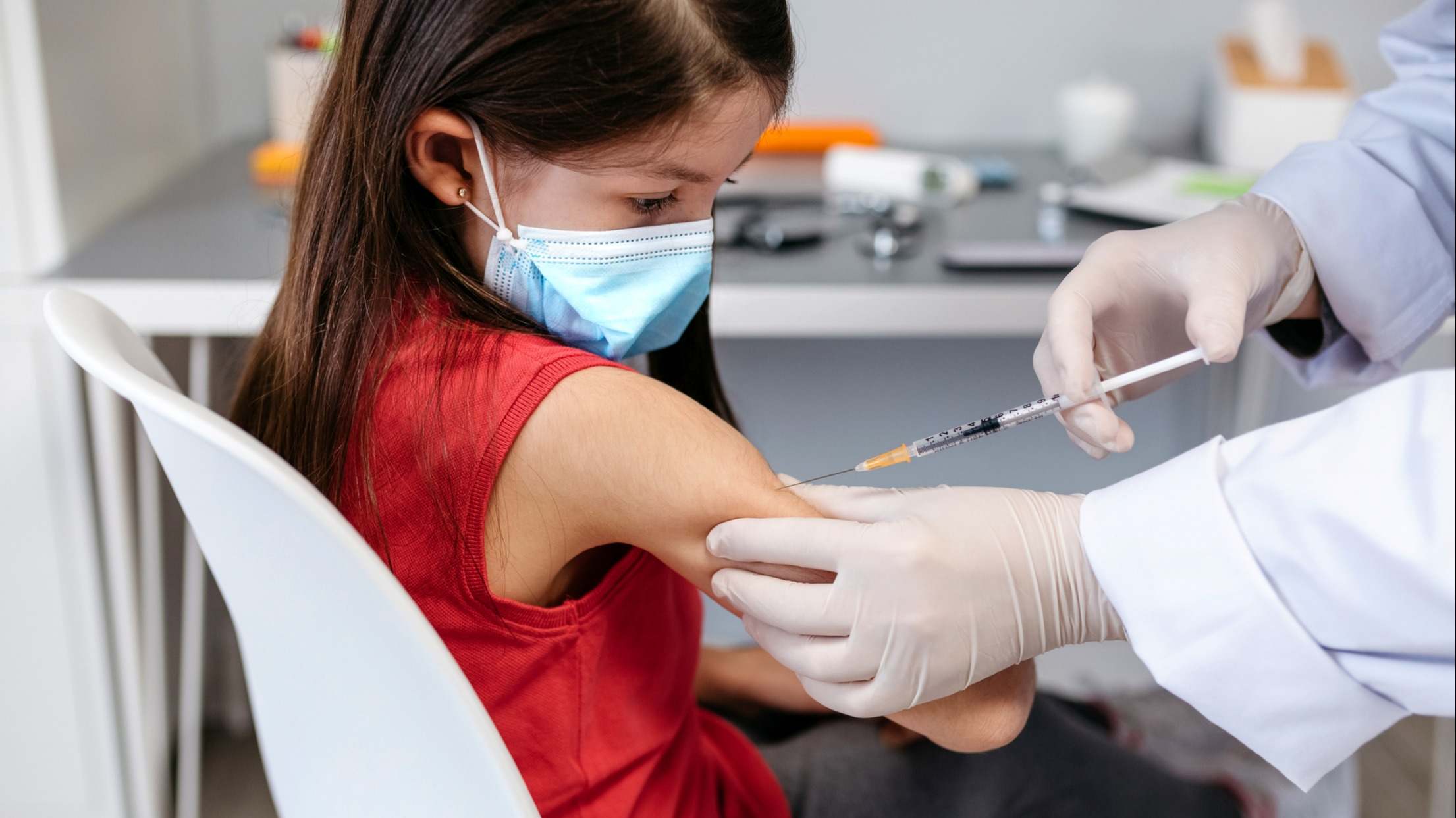 Niña que recibe la vacuna contra el coronavirus en el consultorio del médico