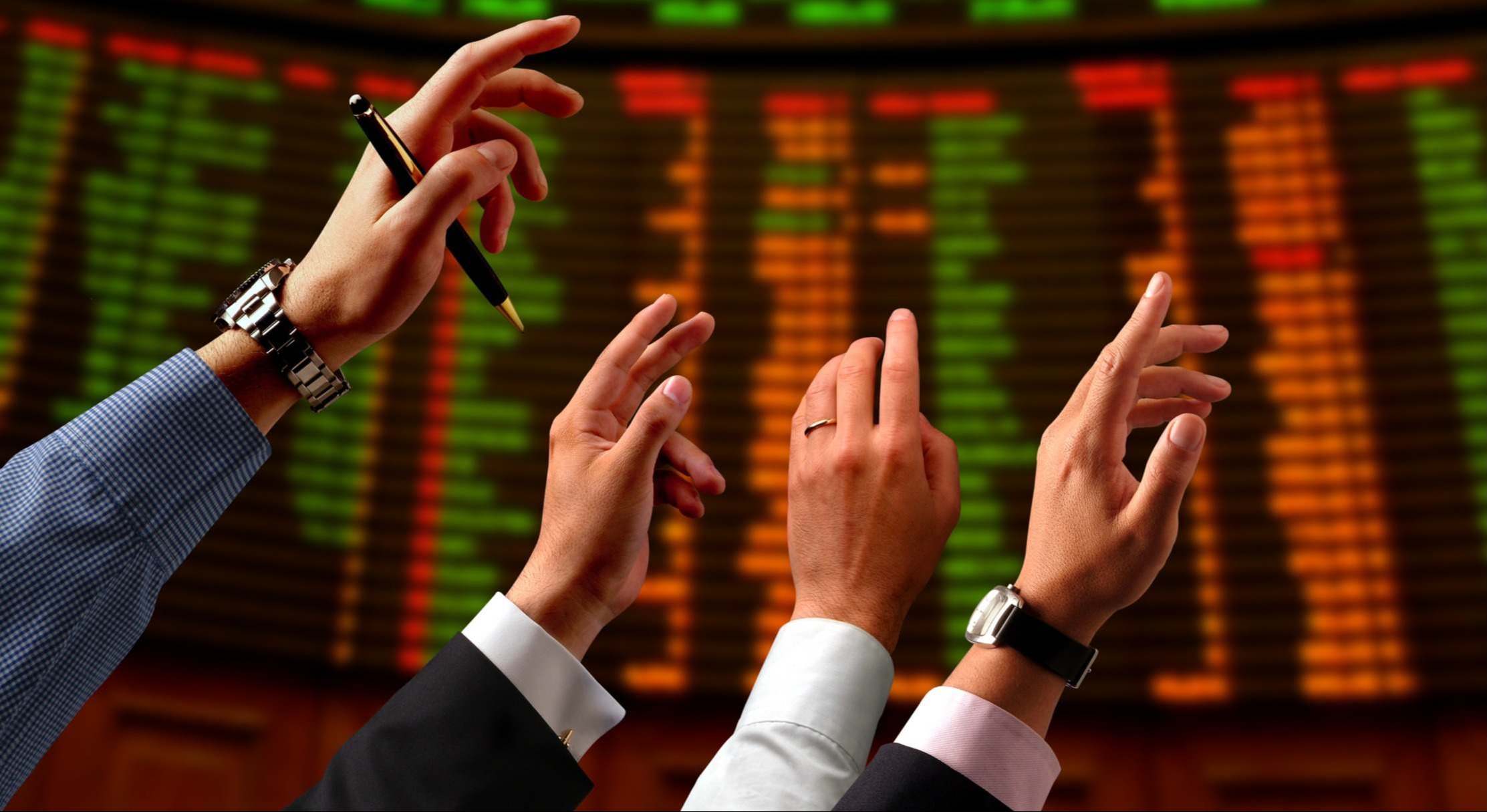 Inversores levantando la mano en la bolsa