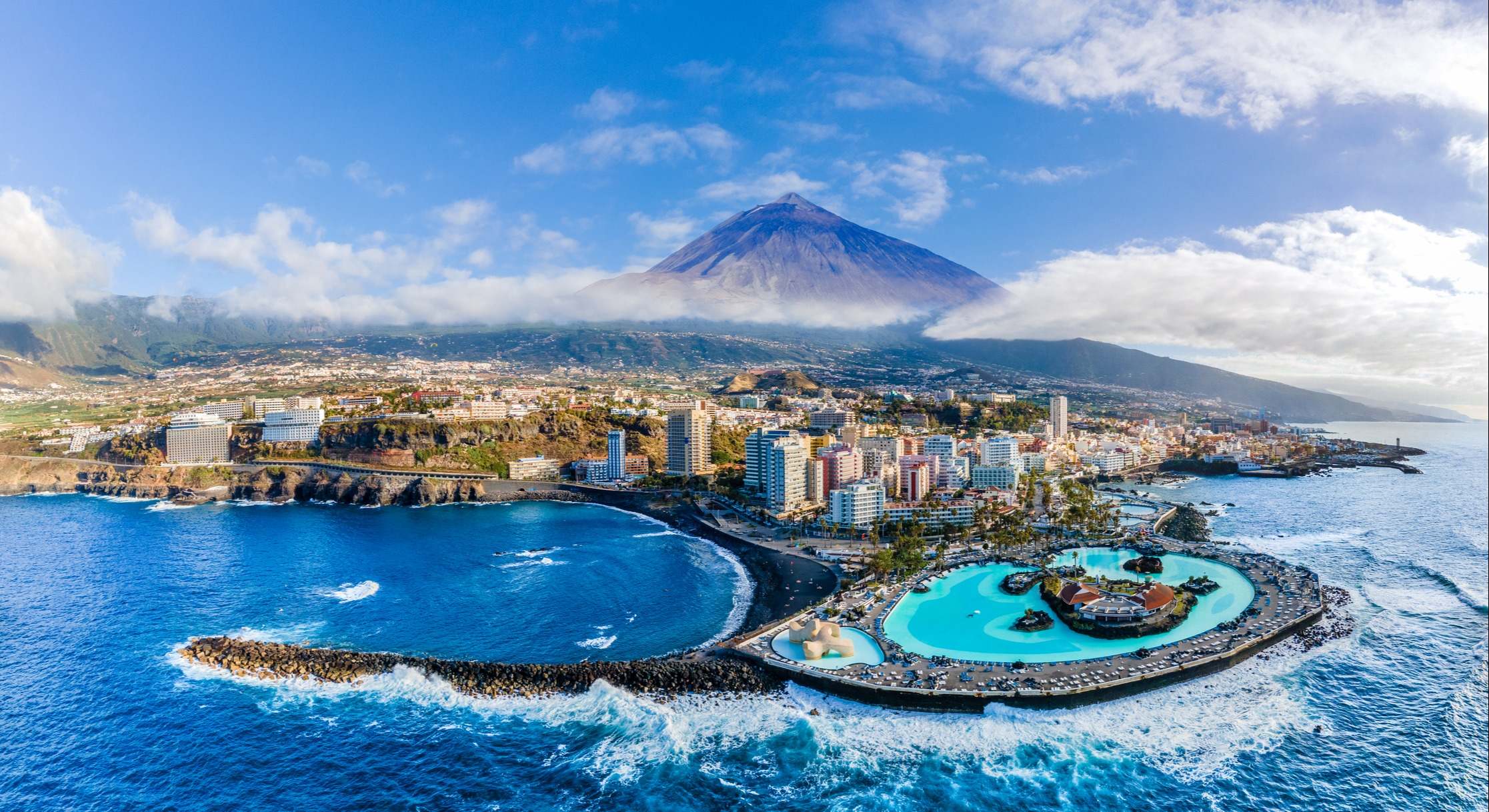 Vista aérea del Puerto de la Cruz en Tenerife donde abundan los rascacielos y hay un pequeño embalse de aguas azules claras