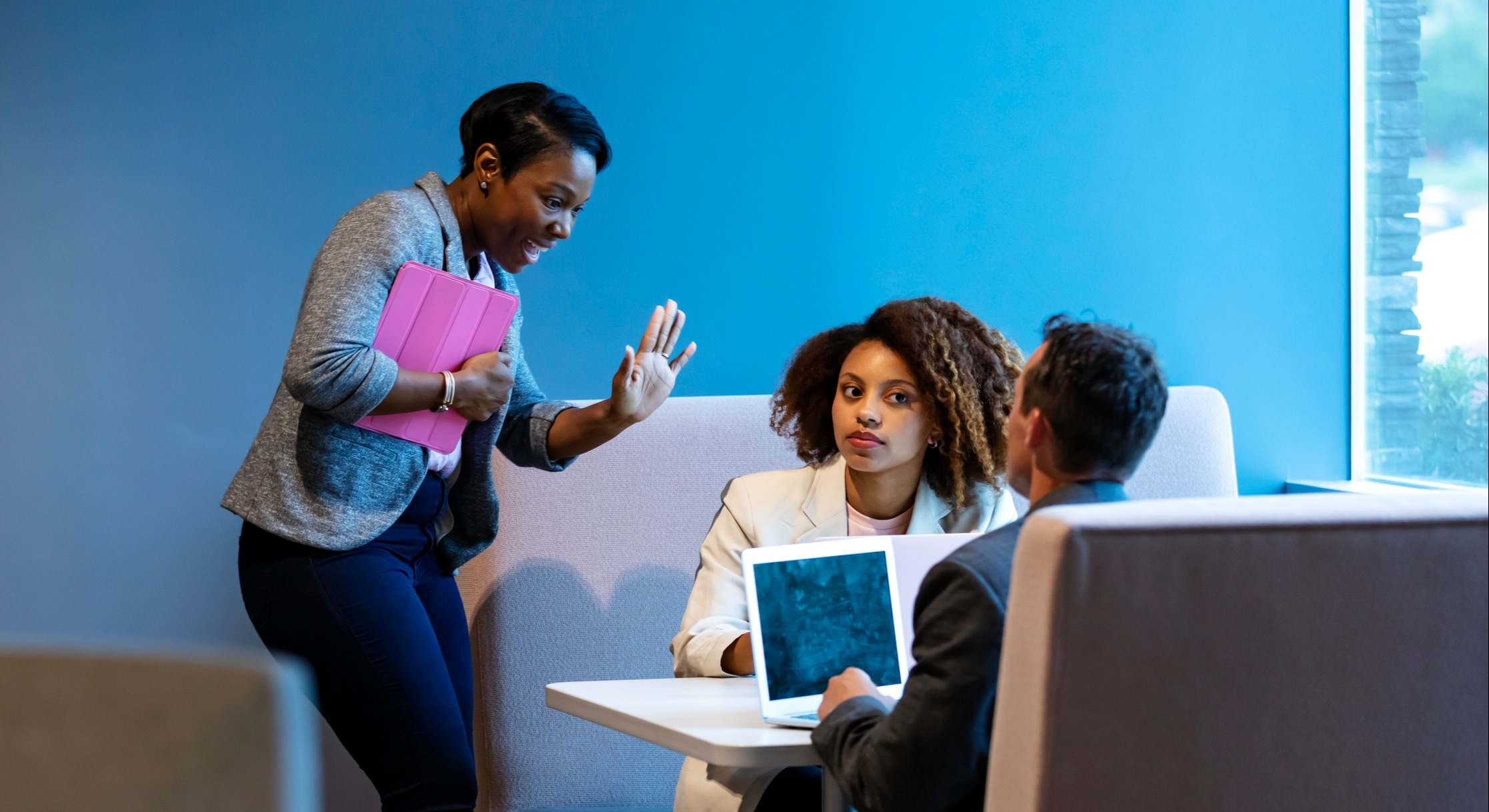 Persona interrumpe una conversación entre dos personas en una oficina