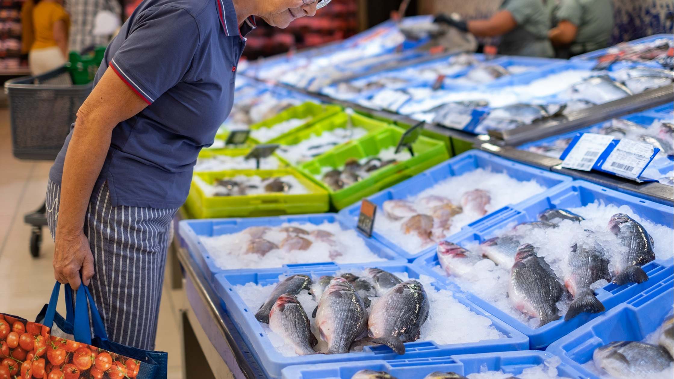 Un cliente comprando en una pescadería de un mercado