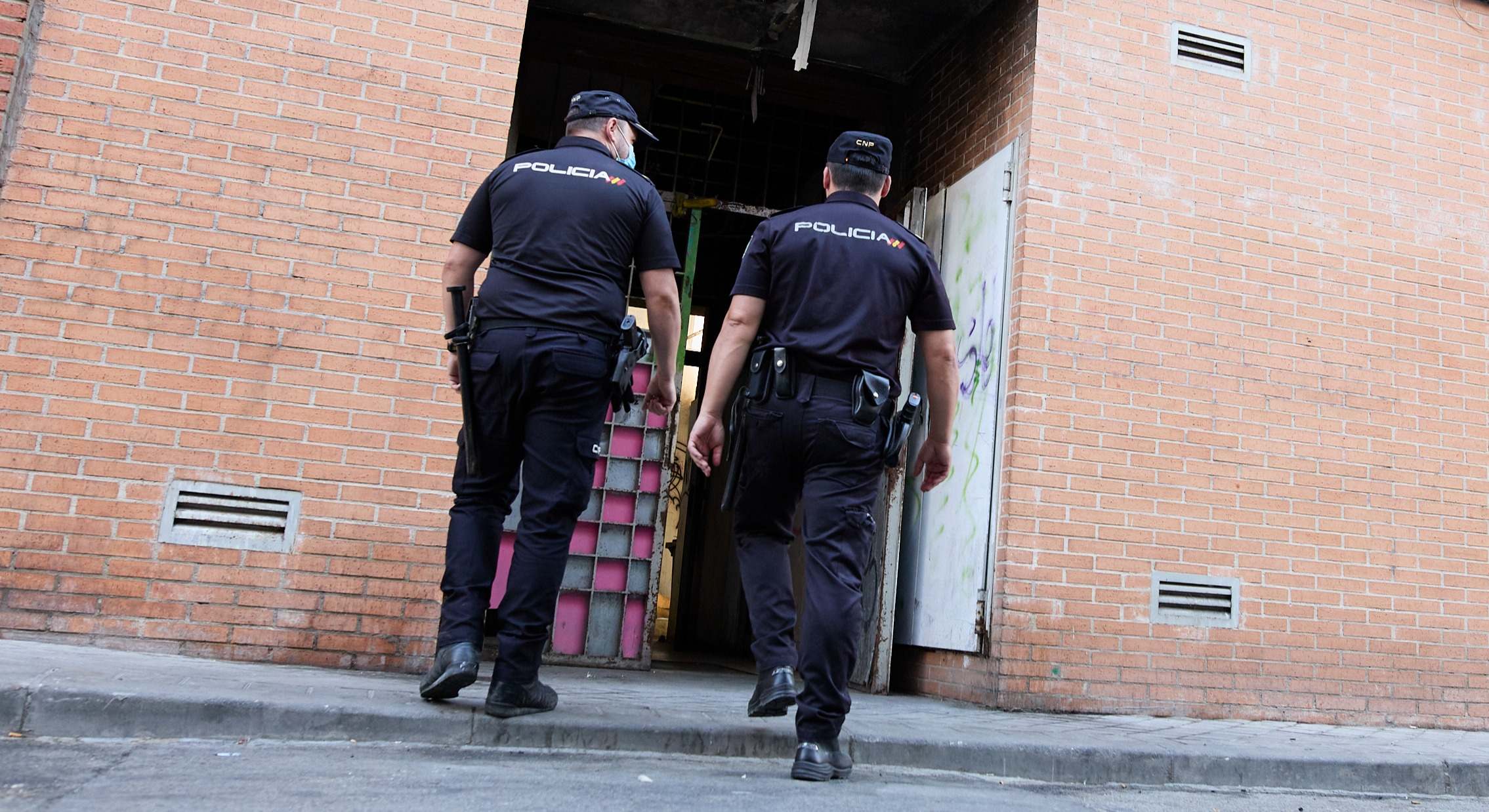 Dos agentes de la Policía entran a desalojar una vivienda