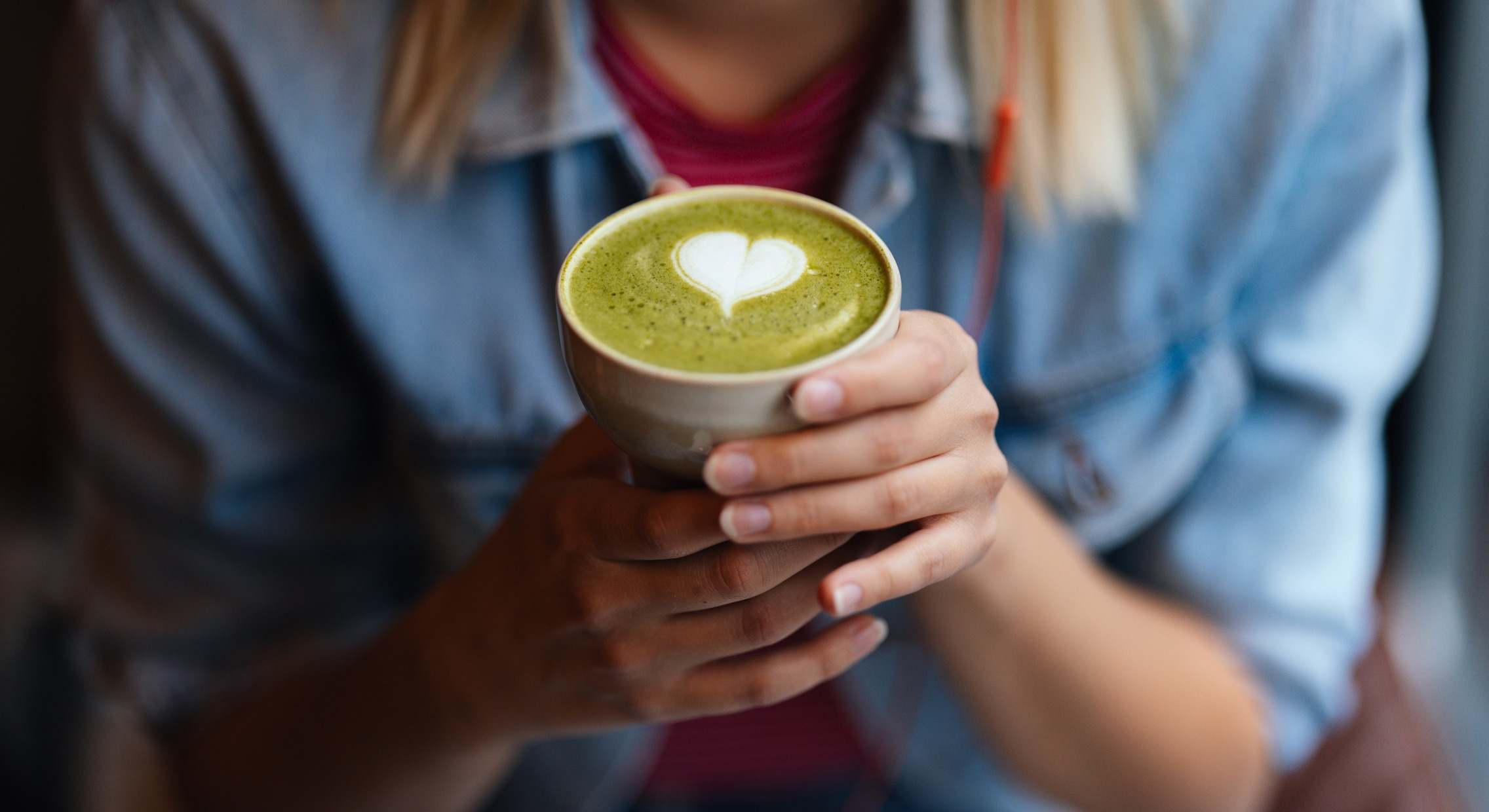 Mujer con un té matcha con espuma verde