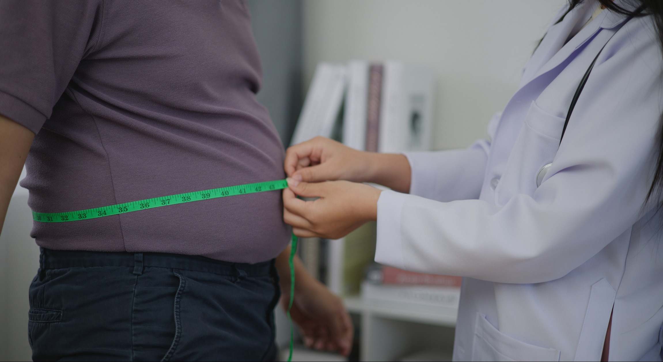 Nutricionista que mide la cintura de un hombre